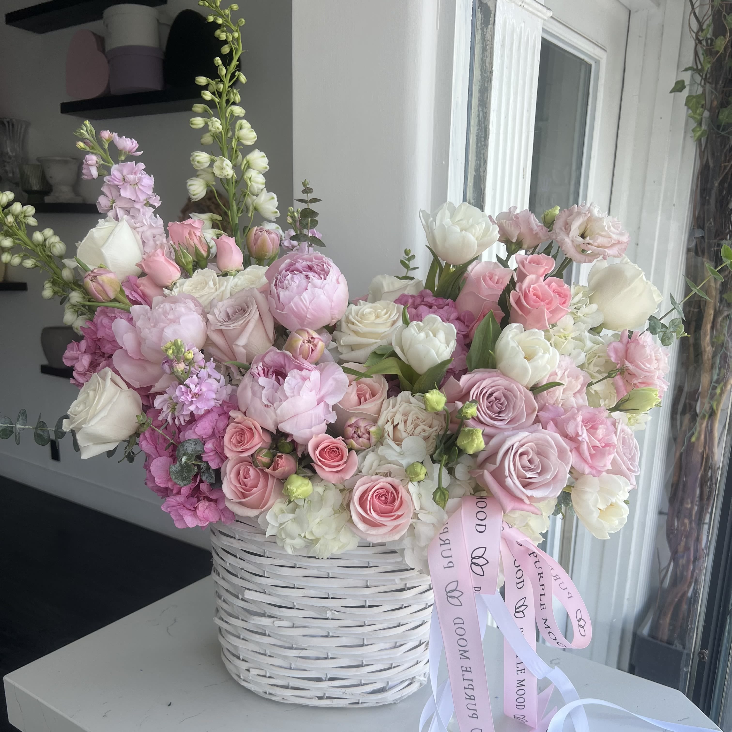 Marshmallow basket Marshmallow basket - An enchanting garden of blush peonies, pastel roses, tulips, and delicate blooms overflowing from a white wicker basket. Designed to impress with soft romance and abundant charm — perfect for Mother’s Day, baby showers, or celebrating life’s sweetest moments. Each basket is made to order. Flower selection may vary slightly based on seasonal availability.