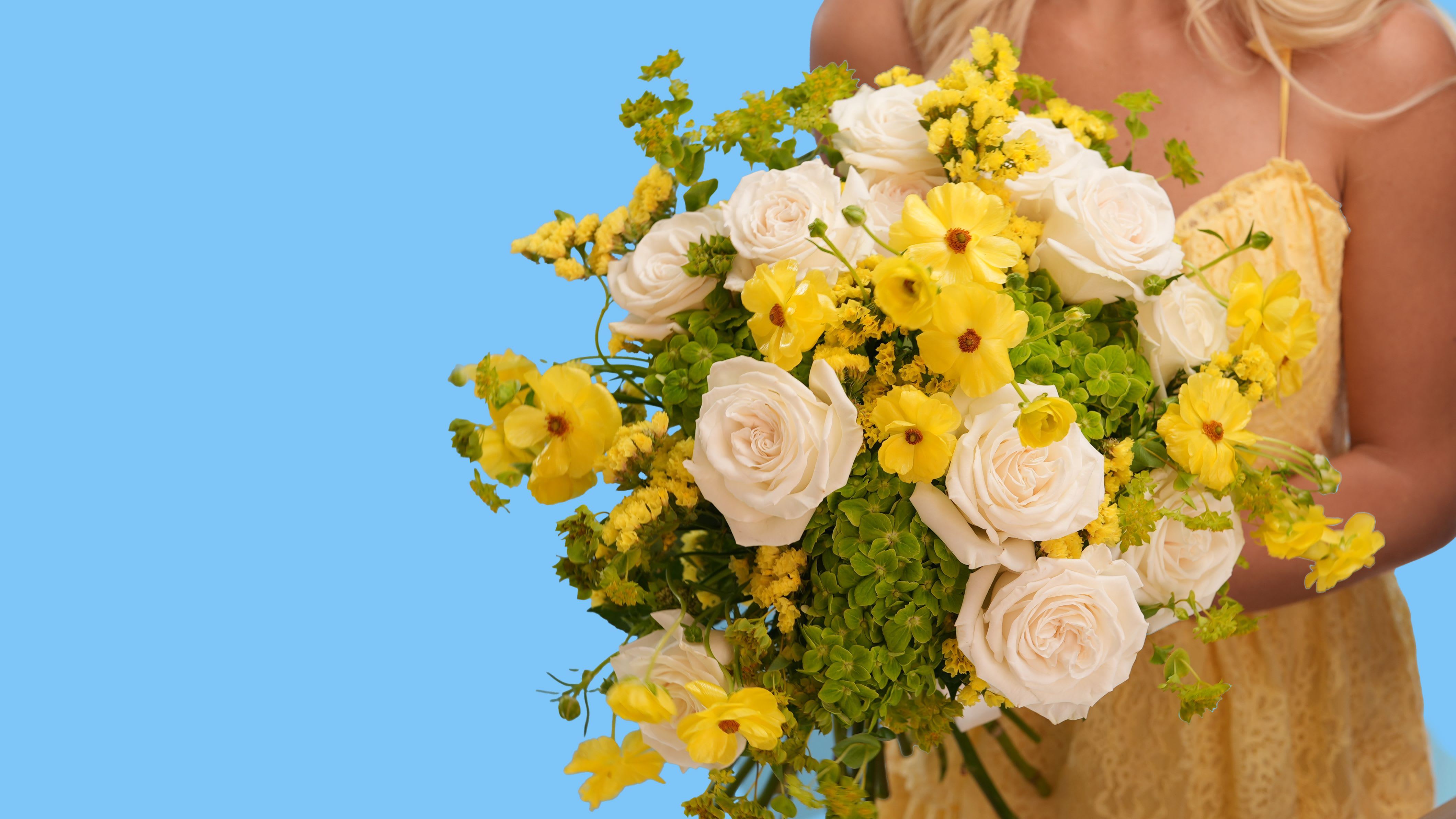 Sunlit kiss - Sunlit Kiss is a burst of pure joy — a radiant blend of soft elegance and golden light. This vibrant arrangement features lush white garden roses, cheerful yellow cosmos, delicate yellow solidago, and seasonal greens. Its sun-drenched palette brings warmth and brightness to any moment.  Whether you're celebrating a new beginning or sending a little extra light, Sunlit Kiss is the perfect floral expression of happiness.  Style: Fresh, modern, joyful Fragrance: Soft, clean floral Best for: Celebrations, birthdays, housewarmings, or “just because”