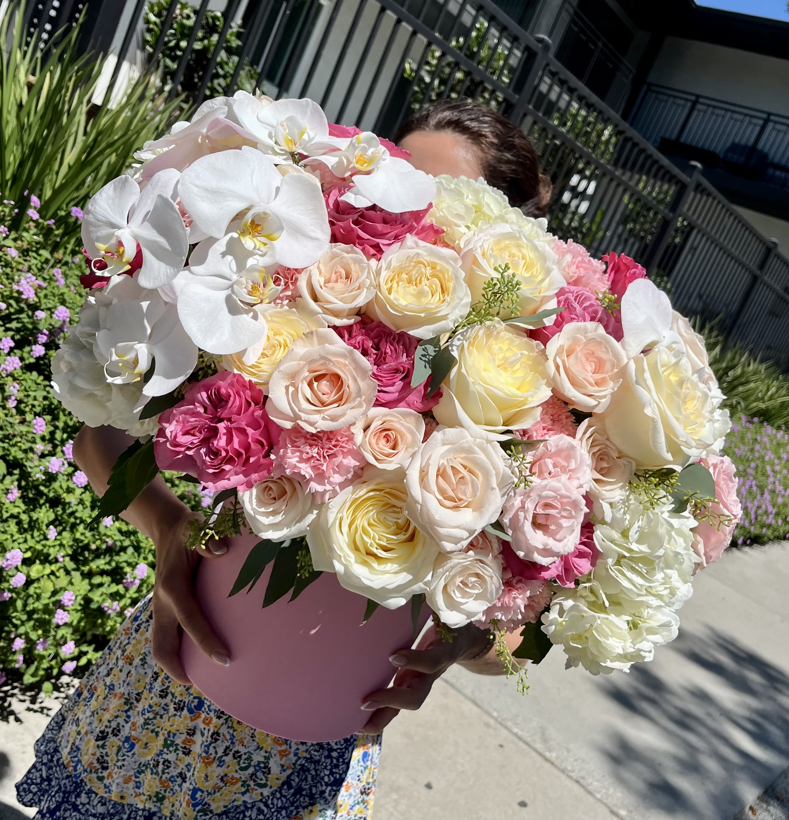 Heavenly Bloom Heavenly Bloom - A divine blend of elegance and charm, Heavenly Bloom is designed to take your breath away. This grand hatbox arrangement features a stunning composition of creamy garden roses, soft blush and peach spray roses, delicate lisianthus, white hydrangeas, and graceful cascading white orchids. It's a statement piece that radiates sophistication and timeless romance. Perfect for weddings, anniversaries, luxury gifts, or celebrating someone truly unforgettable. Style: Romantic, luxurious, angelic Fragrance: Soft rose and orchid notes with a hint of sweetness
