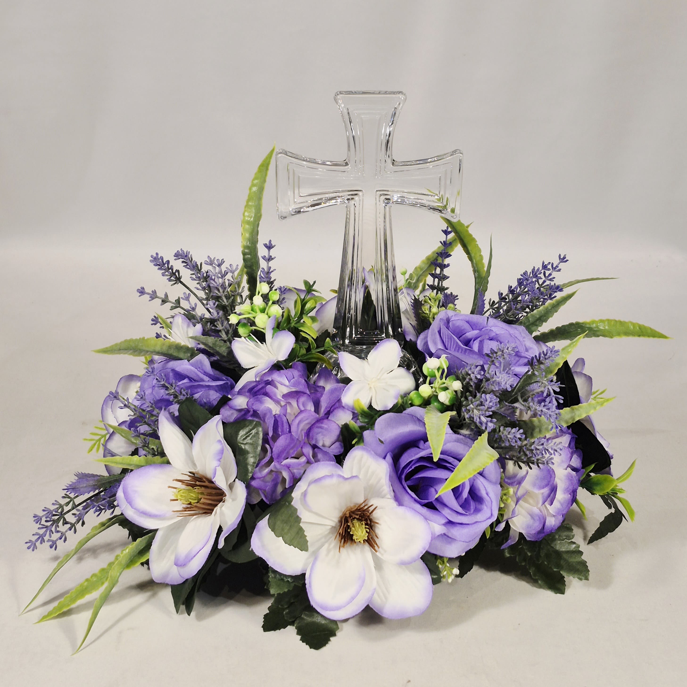 Crystal Cross in Silk Flowers Crystal Cross in Silk Flowers - Silk flowers are a long-lasting way to send care. Set with a keepsake crystal cross, this tribute is a wonderful gift to your loved ones. Wonderful arrangement for birthday, just because, sympathy etc.. Silk flowers are all around this beautiful crystal cross, can be set as a centerpiece for all to enjoy as well. 12" W 12" T
