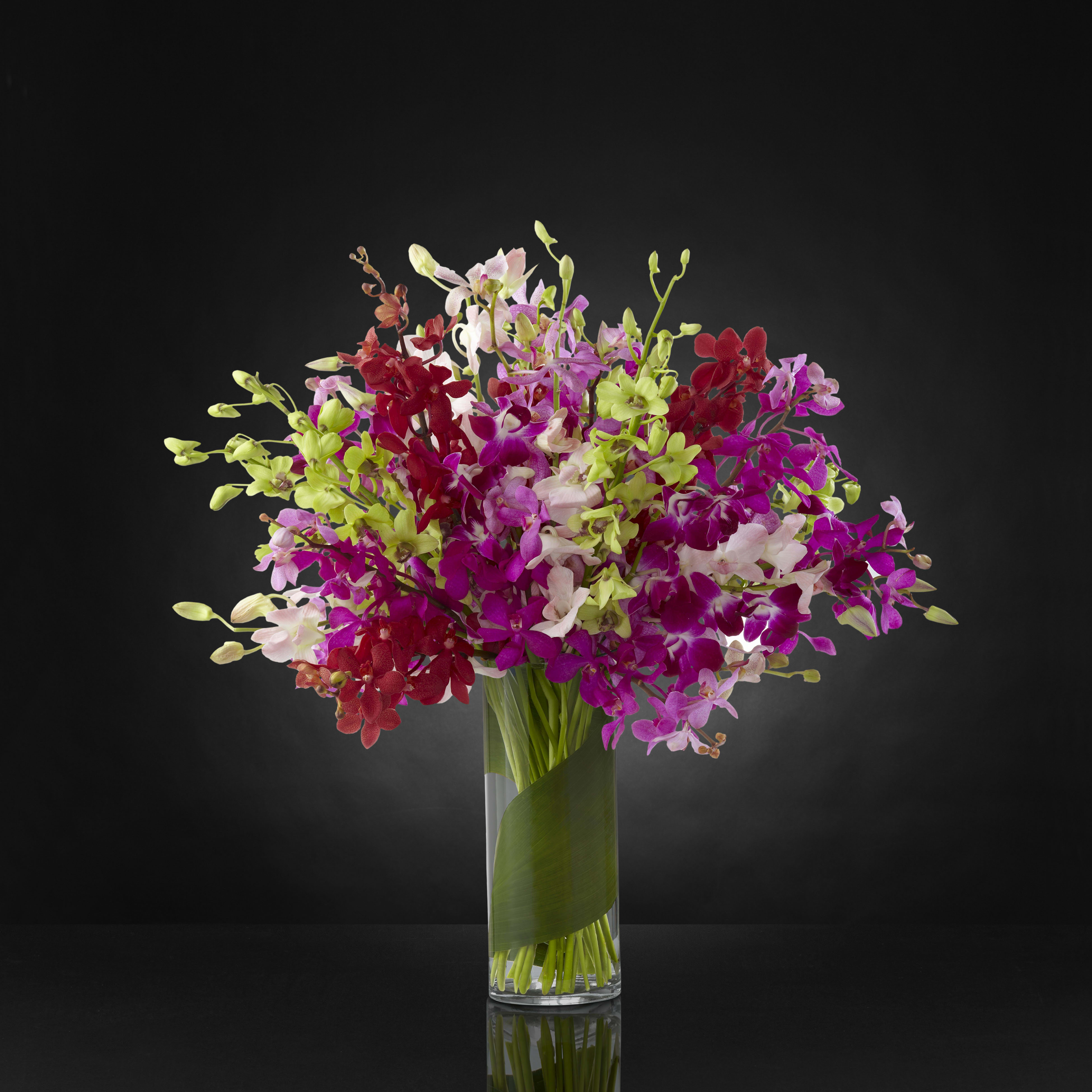Bouquet of colorful orchids in a clear glass vase