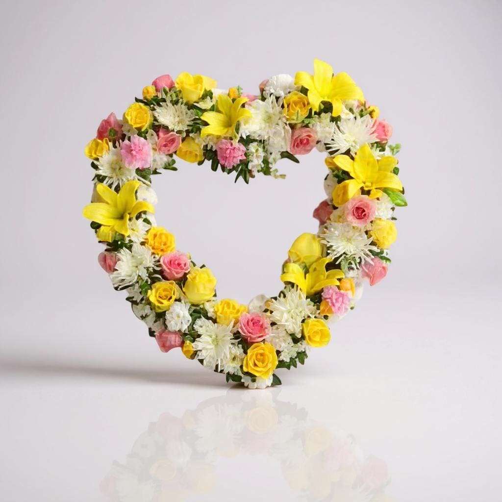 Missing You Heart - An open heart made of white, pink, and yellow blooms including roses, chrysanthemum poms and lilies. 