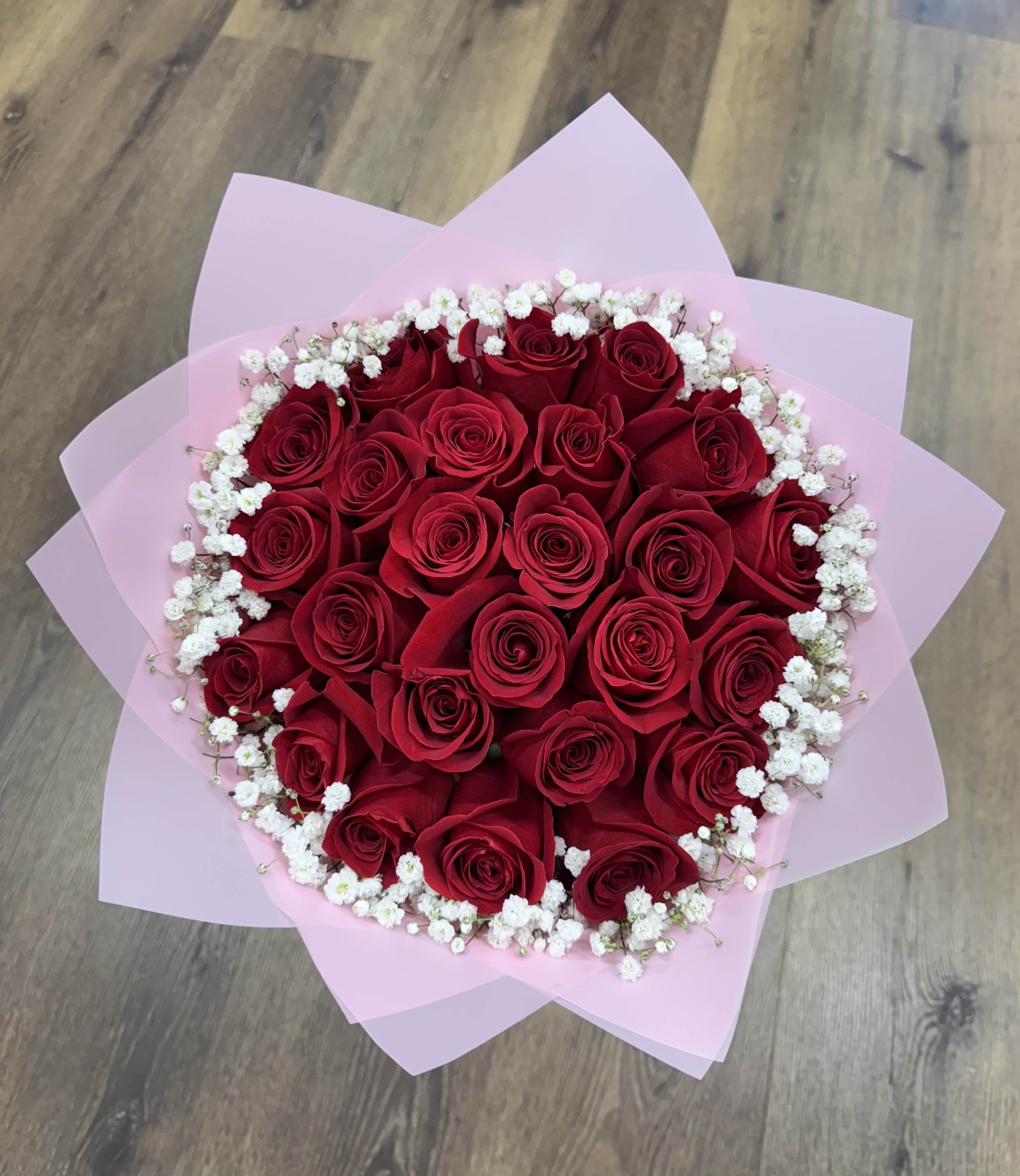 Blush Belle - Soft, graceful, and effortlessly luxurious, the Blush Belle bouquet showcases velvety red roses embraced by a halo of delicate baby's breath and wrapped in soft pink paper. 