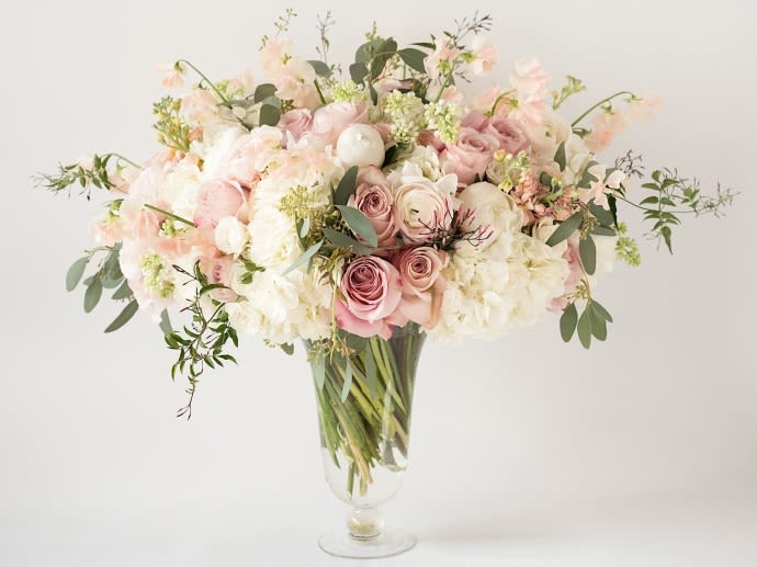 Blush Elegance - A luxurious and versatile floral arrangement featuring blush and dusty pink roses, white peonies, ivory hydrangeas, ranunculus, eucalyptus, and seasonal blooms — all styled in a tall clear glass vase. Elegant and timeless, perfect for weddings, romantic gestures, upscale interiors, or surprise gifts.  Dimensions: Approx. 26&quot; H x 24&quot; W Ideal for: Valentine’s Day, Weddings, Anniversaries, Luxury Centerpieces, Hospitality Decor  #BlushElegance #LuxuryFlowers #WeddingFlowers #RomanticArrangement #PeoniesAndRoses #ElegantCenterpiece #FloristMiami #HighEndFlorals #SurpriseWithFlowers  ESPAÑOL Arreglo floral lujoso y versátil con rosas rosadas empolvadas, peonías blancas, hortensias marfil, ranúnculos, eucalipto y flores de temporada, en un jarrón alto de vidrio transparente. Sofisticado y delicado, ideal para bodas, aniversarios, sorpresas románticas o decoración elegante.  Medidas: Aprox. 66 cm alto x 61 cm ancho Ideal para: San Valentín, bodas, aniversarios, centros de mesa de lujo, decoración hotelera  #BlushElegance #FloresDeLujo #FloresParaBoda #ArregloRomántico #CentrosDeMesa #PeoníasYRosas #FloristeríaMiami #FloresDeAltaGama #SorpresasConFlores