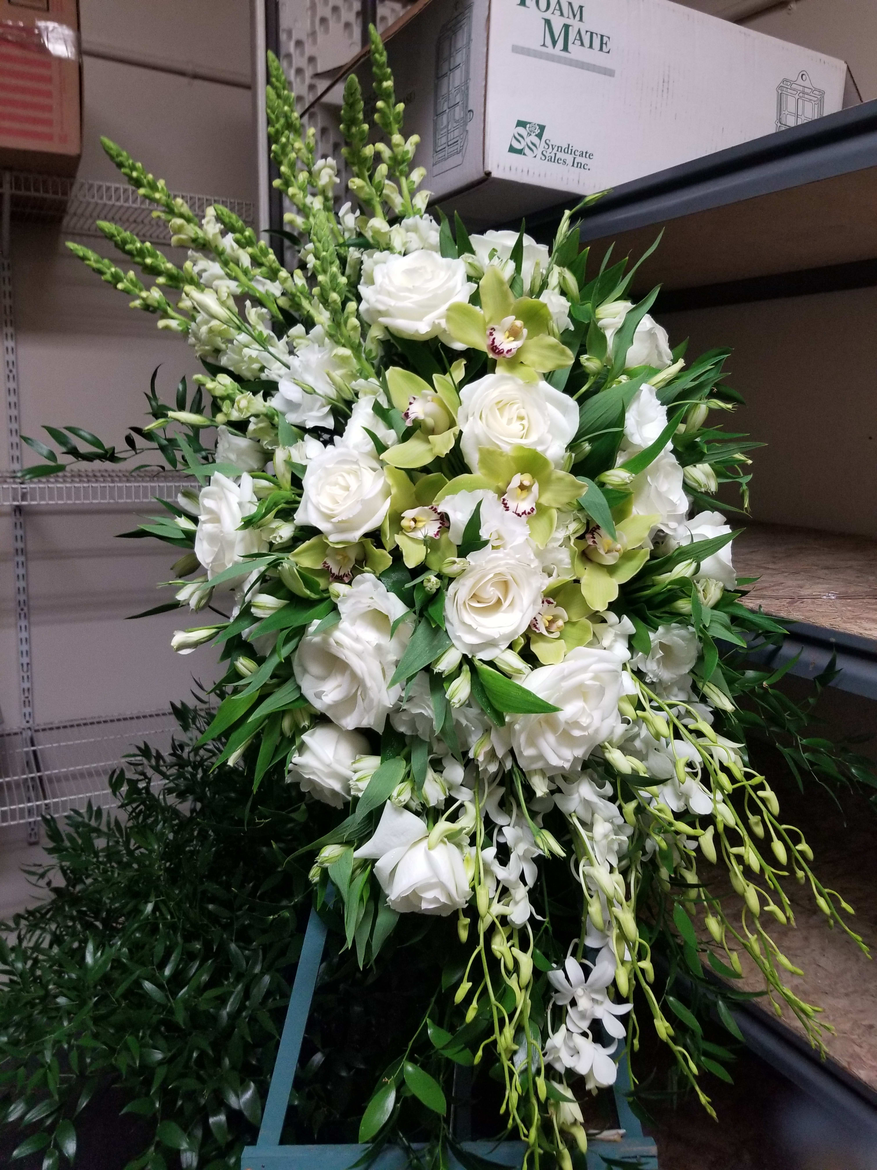 White &amp; Green Sympathy Spray  - *DELUXE VERSION SHOWN* Classic sympathy spray for the service. Can be made in any color you choose.  White roses, snapdragons, orchids, alstromeria .**24 hour advance ordering is required for exact flowers.  Due to market limitations at this time some flowers may not be available.