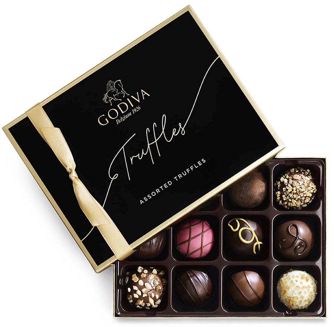 Godiva Premium Chocolate Truffles (12 pc) - ntroducing the renowned Godiva Assorted Chocolate Truffles, now available at Watanabe Floral. This exquisite box contains 12 of Godiva's legendary truffles, each one a masterpiece of fine chocolate craftsmanship. Featuring a delightful assortment of flavors, these truffles offer a luxurious taste experience that will satisfy even the most discerning chocolate lover. Perfect for gifting or indulging in a moment of personal luxury, this box of assorted truffles is sure to impress.  Key Features:  Assorted Flavors: A diverse selection of 12 truffles, each with its own unique flavor profile. Premium Quality: Crafted from the finest ingredients to deliver rich, indulgent flavors. Perfect for Gifting: An ideal choice for any occasion, from special celebrations to thoughtful gestures. Elegant Presentation: Packaged in a beautifully designed box, ready to delight recipients.