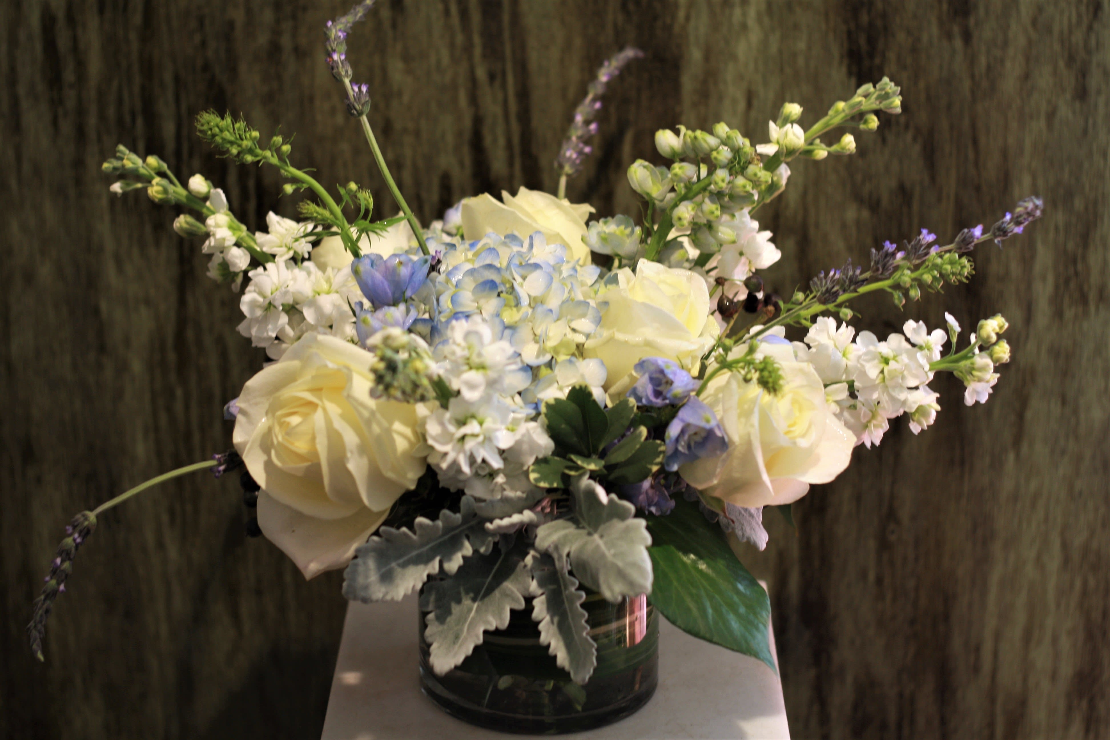 Welcome Baby Boy - The perfect way to congratulate a new mother &amp; to welcome the new baby boy! This airy arrangement combines roses, hydrangea, delphinium and accents in baby blues and whites.  Your arrangement will be designed in the style shown but flowers and containers may be different from that pictured.