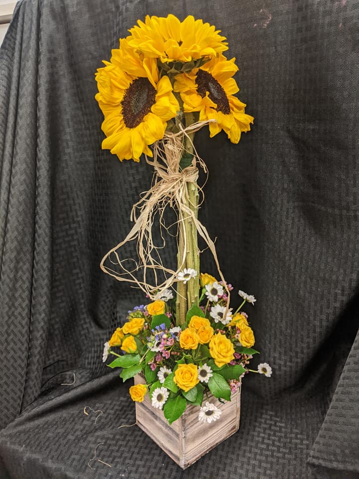 Sunflower sunshine (Pictured in Delux) Sunflower sunshine (Pictured in Delux) - Pictured in Deluxe This yellow ray of sunshine just can't contain himself. Full of joy and flowers this bouquet delivers with two tiers of bright yellow blossoms! It's magical!!! This beautiful arrangement contains Big beautiful Sunflowers making a topiary above livley yellow Roses and daises