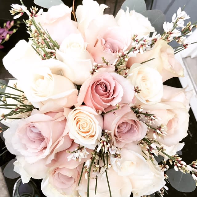 Blushed Bridal Bouquet by Barb's Flowers Blushed Bridal Bouquet by Barb's Flowers - Quicksand Roses (Blush), Vendela Roses (Creme) are put together with a nice in season filler. Pictured is Ginestra. Not always available but there are many things that are similar.. This Bridal Bouquet was finished off with a Raw Silk Ribbon Fabric around the handle and pear pins.