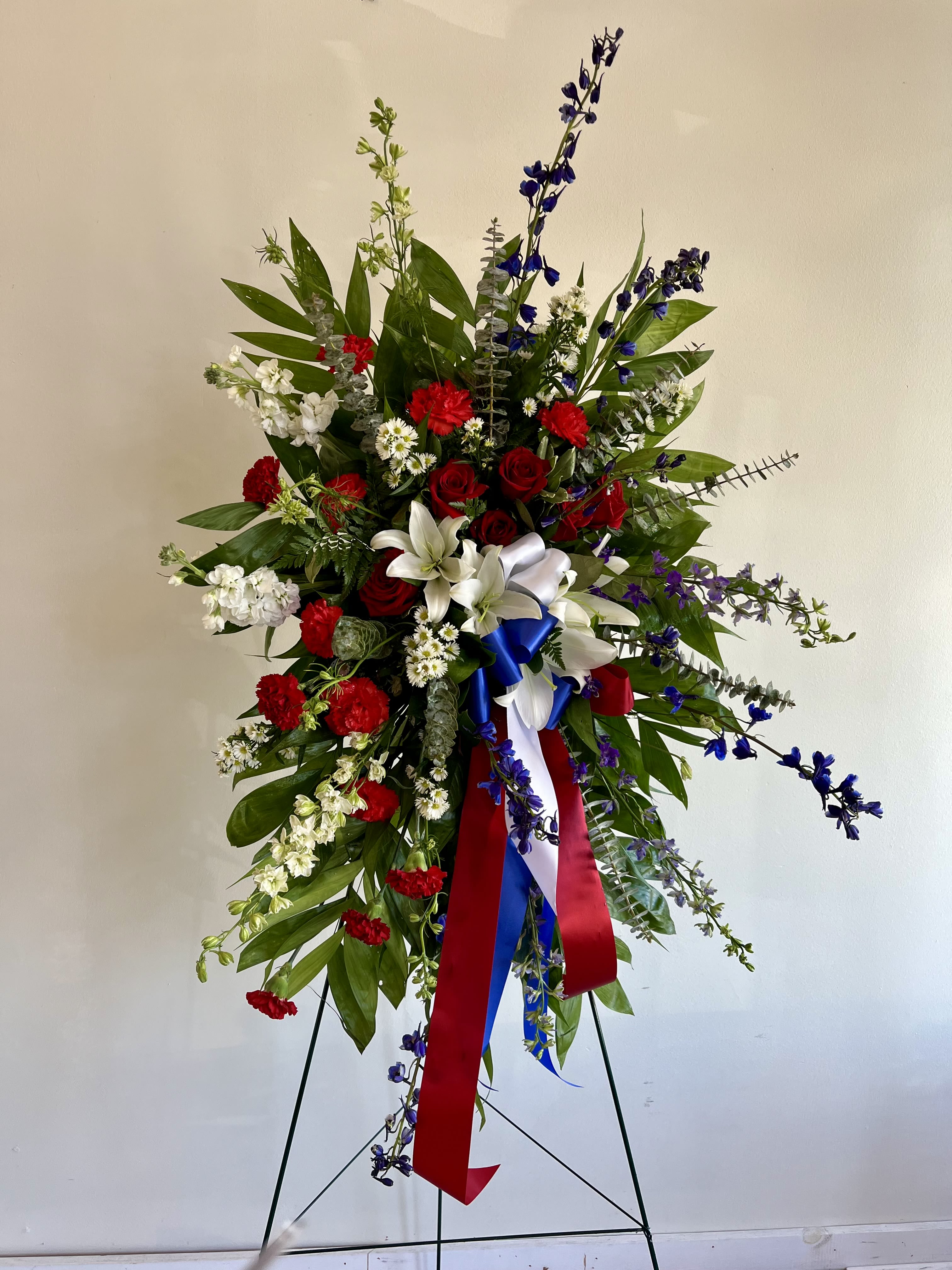 Open Heart Sympathy Wreath Open Heart Sympathy Wreath - Send a harmonious message of hope and honor with this beautiful standing spray with blue, red, and white to pay tribute to a loving spirit. Stands on a 54"- 60” easel. Size shown is deluxe.