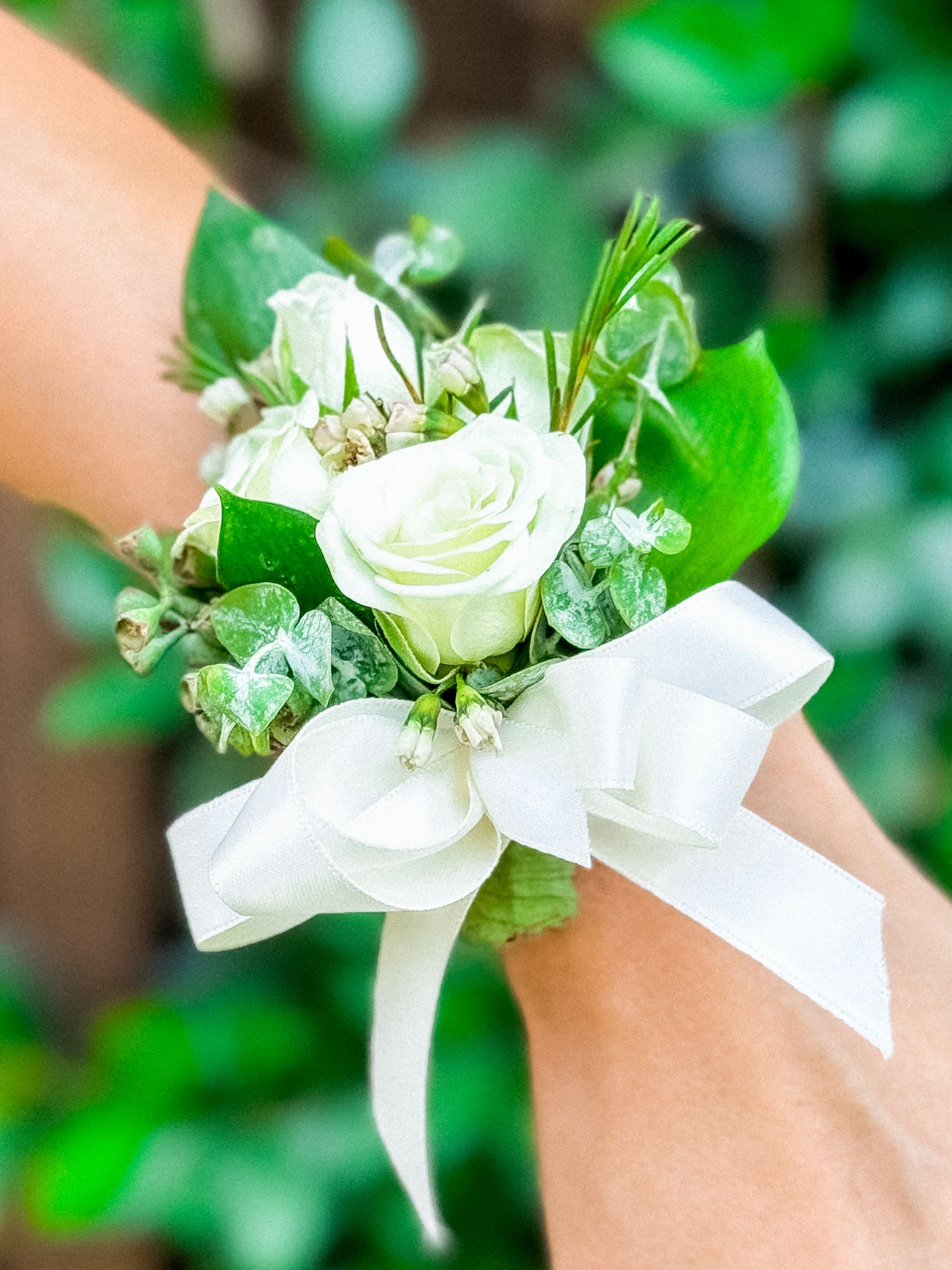 Halo Hold  - Okay, so this lil’ beauty? We call her Halo Hold - because it literally feels like a tiny flower halo just wrapped itself around your wrist and said, “You’re divine.” It’s soft, dreamy, romantic AF and goes perfectly with Zelenaflora’s most iconic bridal bouquets - Bridal Bliss, Vow Vibes, Lover Loop, and Petal Pact. Whether you’re a bride, maid of honor, or just vibin’ at a summer rooftop wedding in Malibu, this corsage is giving &quot;effortlessly elegant.&quot; Delicate mini white roses and lush greenery pop against a silky white ribbon - tied just right, not too fussy. You get classic vibes with a modern twist, like garden glam meets LA cool. 