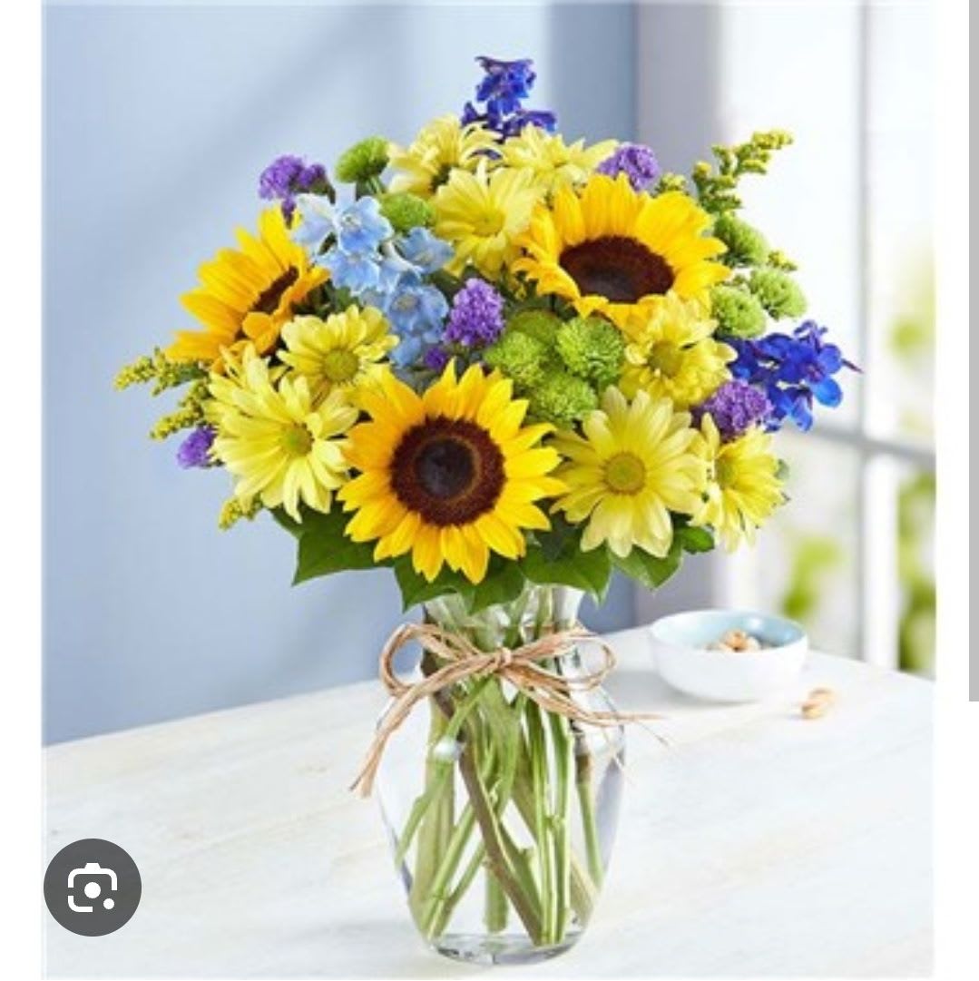 Golden Bloom - Bright, cheerful and effortlessly elegant. Featuring sunflowers, white daisies and delphinium beautifully arranged in a modern clear glass vase.