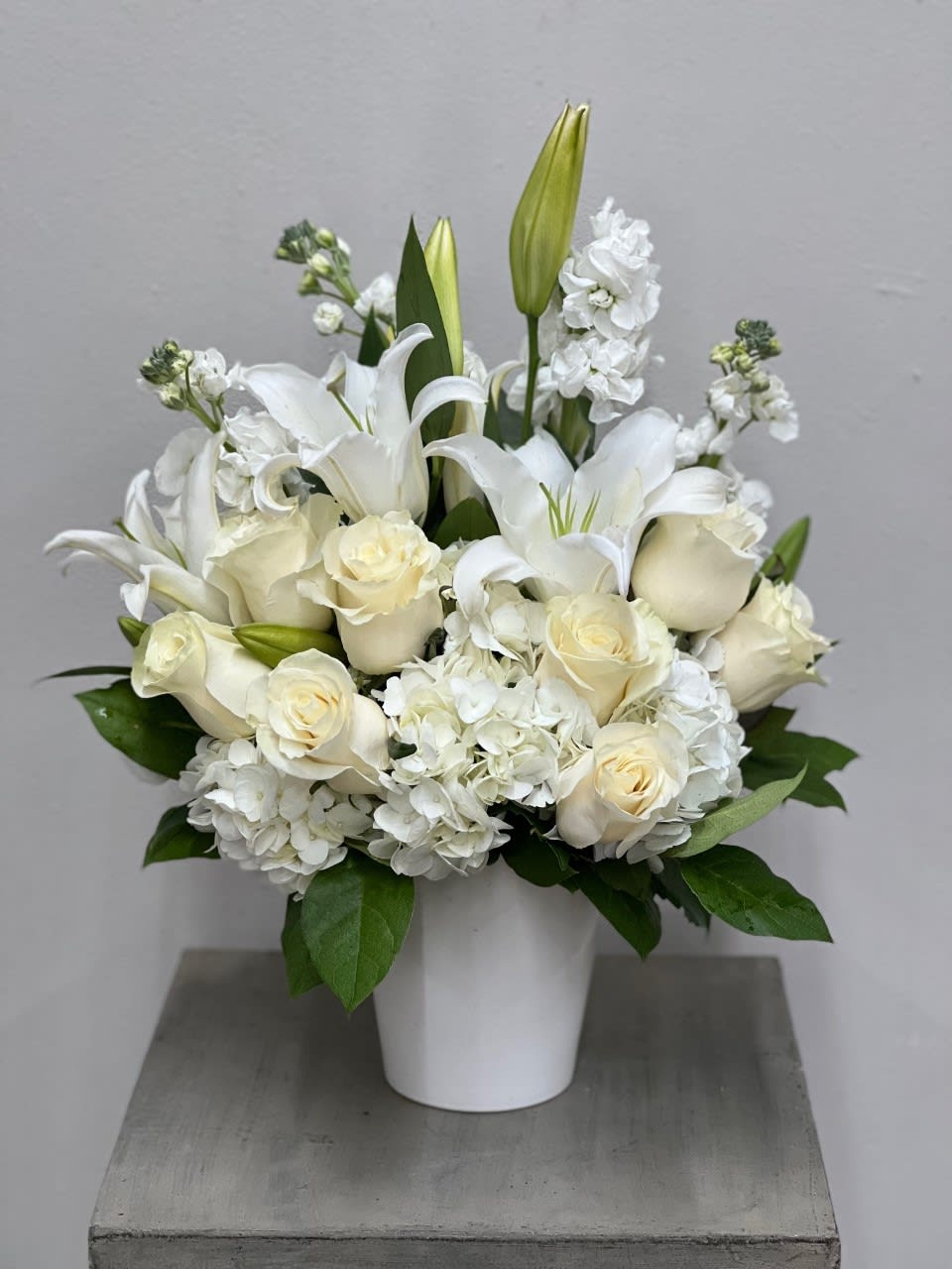 All In White Bouquet All In White Bouquet - All white assortment of lilies, roses, hydrangeas and stock arranged together with rich greenery in a white container. For local delivery ONLY. Container may vary.