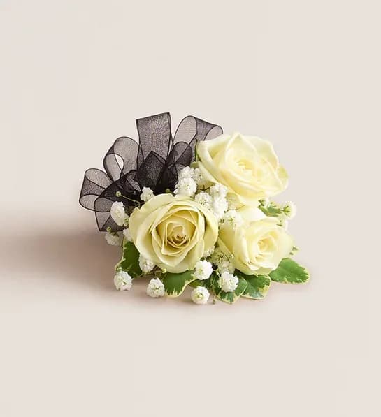 White Spray Rose Corsage - NEW A dreamy finishing touch to a wedding gown, a prom dress, or any other special-occasion finery. Consisting of carefully selected white spray roses complemented with baby’s-breath and greenery, our corsage comes with ribbon in your choice of eight colors: black, gold, green, lavender, light pink, royal blue, silver, or white. Available in two sizes, the corsage can be worn on the wrist or pinned to clothing.