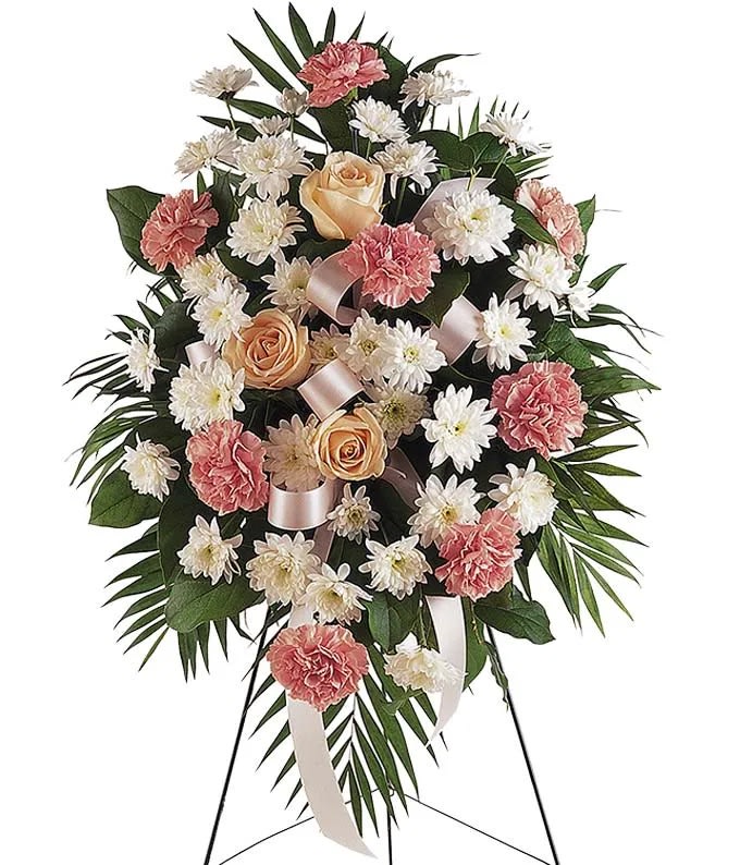 Mutli-Color Floral Sympathy Standing Spray - Florist of Omaha Mutli-Color Floral Sympathy Standing Spray - Florist of Omaha - The Multi-Color Floral Sympathy Standing Spray is a beautiful funeral gift to send in memorial of someone who has passed. Created with seasonal pastel flowers including carnations, Chrysanthemums and roses. The flowers are arranged in an oval shaped on a standing spray design to be placed in a funeral home during a service. Premium measures approximately 39"H x 42"L without stand Deluxe measures approximately 36"H x 40"L without stand Standard measures approximately 34"H x 36"L without stand Includes: • Pink Carnations • White Spray Chrysanthemums • Pastel Roses • Decorative Pink Ribbon • Sympathy Stand