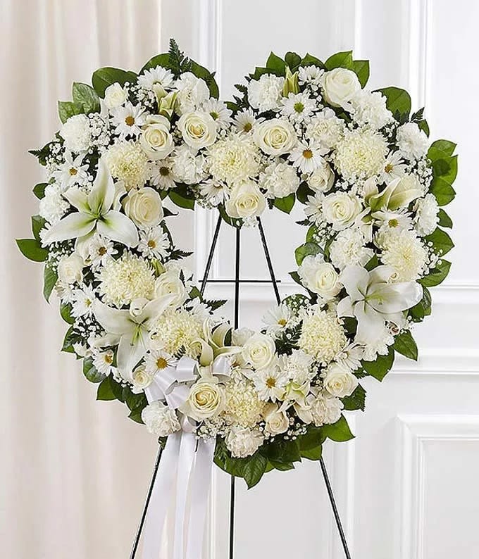 White Standing Open Heart - Florist of Omaha White Standing Open Heart - Florist of Omaha - Convey your sympathy and love with an all white open heart standing spray. Arranged by a florist with fresh white roses, lilies, carnations and more. Accented by salal, baby's breath and leather leaf, this sympathy standing spray can be delivered with a card. Measures approximately 34"H x 32"W without easel. Includes: • White Roses • White Lilies • White Carnations • Satin Ribbon • Open Heart Design