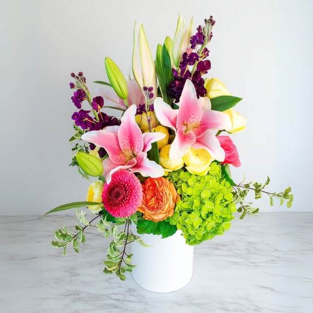 Aroma Aroma - A sensory delight with flowers like yellow roses, stargazers, and green hydrangea, wrapped in fresh foliage.