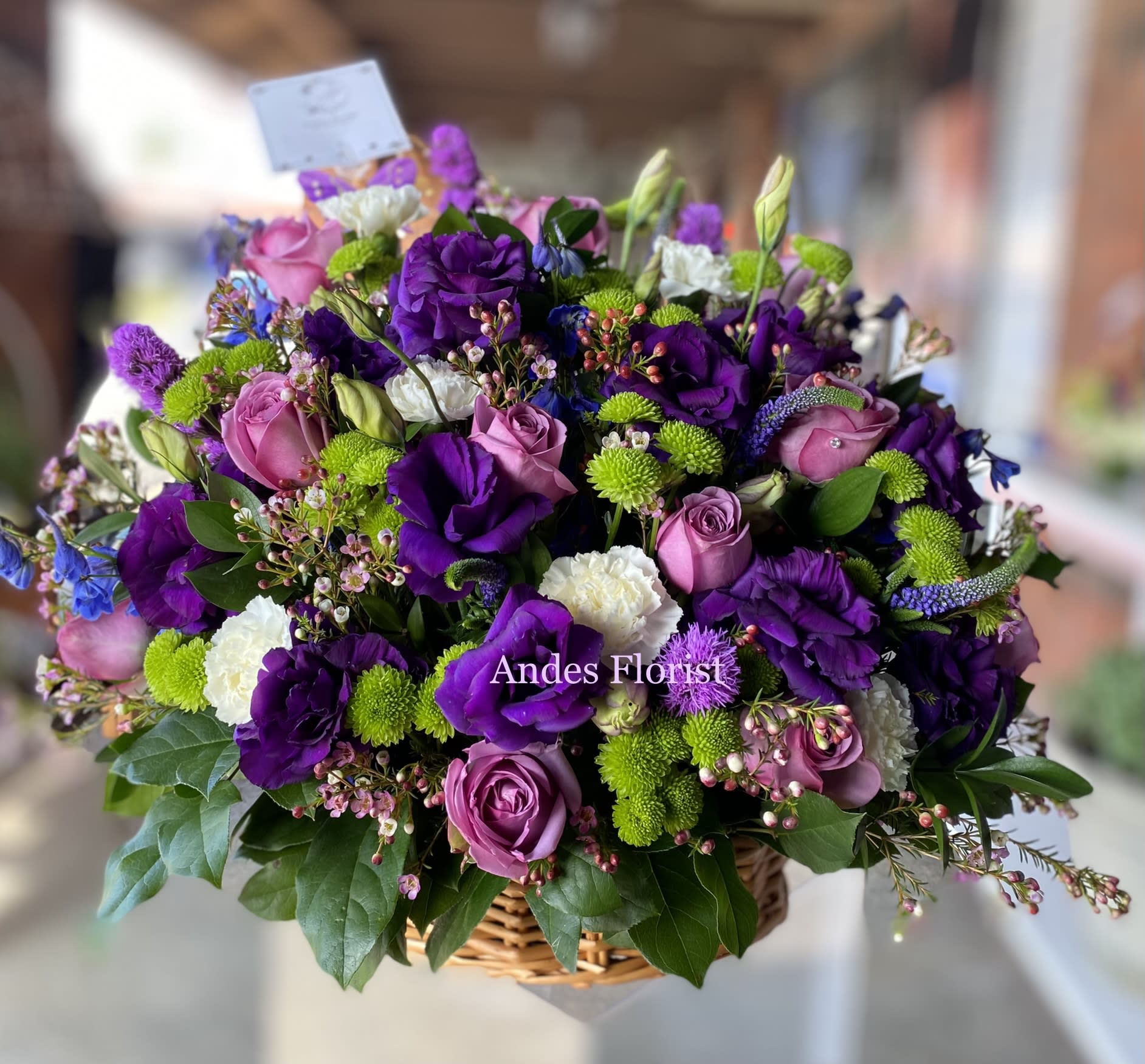 Lavender Basket - Soothing jewel tones of lavender and purple come together to celebrate a life and comfort friends and loved ones an abundant basket of fragrant country blooms that pays tribute to someone truly special. Purple and lavender petals abound in a lovely mix of flowers such as roses, lisianthus and more, nestled among leatherleaf fern and eucalyptus in a round wicker basket. Approximately 24 1/2&quot; W x 28&quot; H.