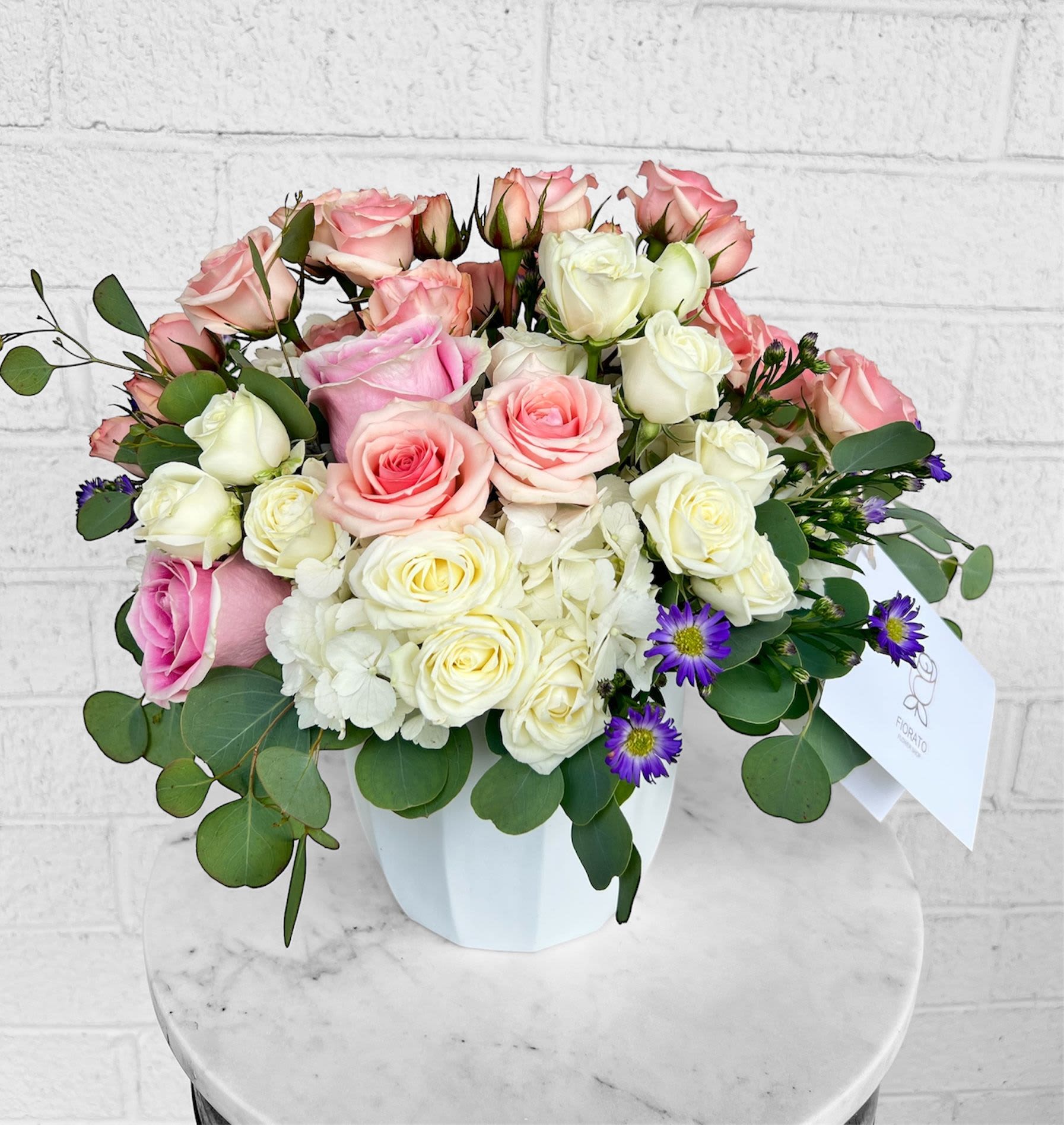 Savannah Bloom  - A graceful arrangement inspired by the romantic charm of the South. Featuring blush and ivory roses, white hydrangeas, soft eucalyptus, and hints of lavender daisy accents—this bouquet captures the essence of elegance and serenity. Perfect for celebrating love, new beginnings, or simply brightening someone’s day.