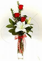 Elegant Romance Lily & Rose Bouquet Elegant Romance Lily & Rose Bouquet - Make a graceful statement this Valentine’s Day with the Elegant Romance Lily & Rose Bouquet. This simple yet stunning arrangement features vibrant red roses—the timeless symbol of love—paired with a striking pure white lily, representing purity and devotion. Accented with fresh greenery and tied with a charming red ribbon, this bouquet exudes sophistication and heartfelt sentiment. Presented in a sleek, clear glass vase, this arrangement is perfect for celebrating new love, long-lasting relationships, or expressing admiration in a meaningful way. Why It’s Perfect for Valentine’s Day: Classic Red Roses: Symbolizing deep love and passion. Elegant White Lily: A touch of purity and timeless beauty. Charming Red Ribbon: Adds a romantic, festive flair. Sleek Glass Vase: Ready for display, making it an effortless yet thoughtful gift. Show your love with the Elegant Romance Lily & Rose Bouquet—a gift that’s as beautiful and meaningful as the person receiving it. ️