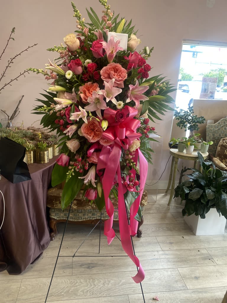 Heavenly Embrace - Soft, graceful, and full of tender beauty, our &quot;Heavenly Embrace&quot; standing spray is a loving tribute to a cherished life. This delicate arrangement blends the gentle blush of pink garden roses, spray roses, stock, snapdragons and lilies with the pure elegance of white roses.  These lovely flowers will offer comfort and peace at this sorrowful time. They symbolize affection, sympathy, and serenity.  Expertly handcrafted, &quot;Heavenly Embrace&quot; stands as a beautiful and uplifting symbol of eternal love.