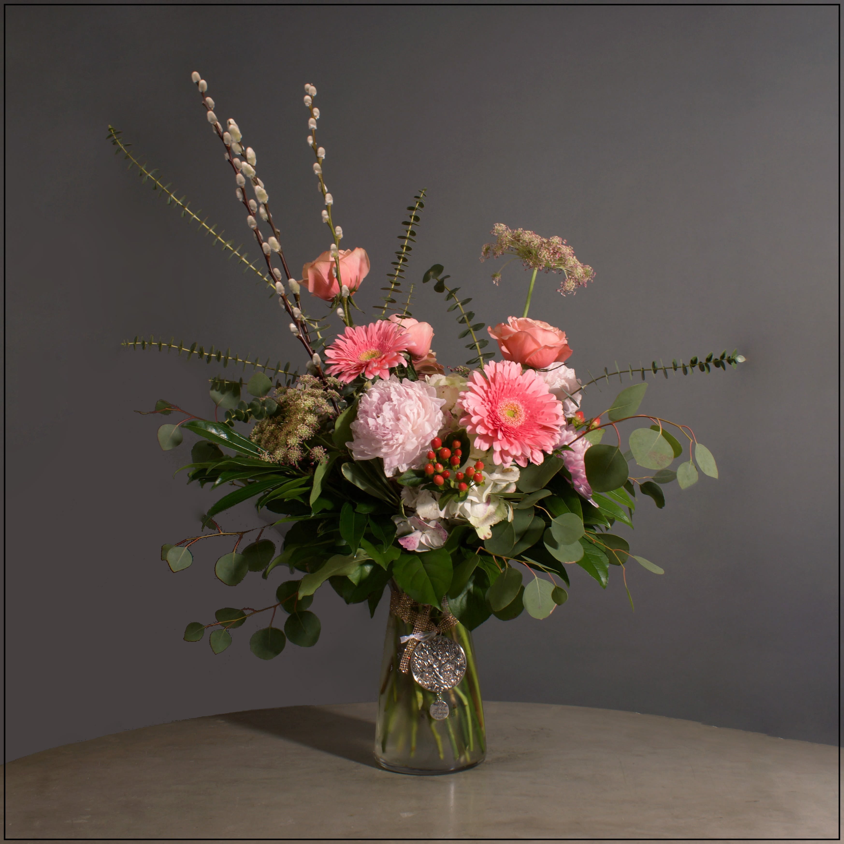 My First Friend My First Friend - Glass vase with a mix of pink and and peach, including peonies, roses, antique hydrangea, gerber daisies, cremones, hypericum, Queen Anne's Lace, accented with a lovely mix of greenery and pussy willow. Approximately 40" tall and 18" wide.