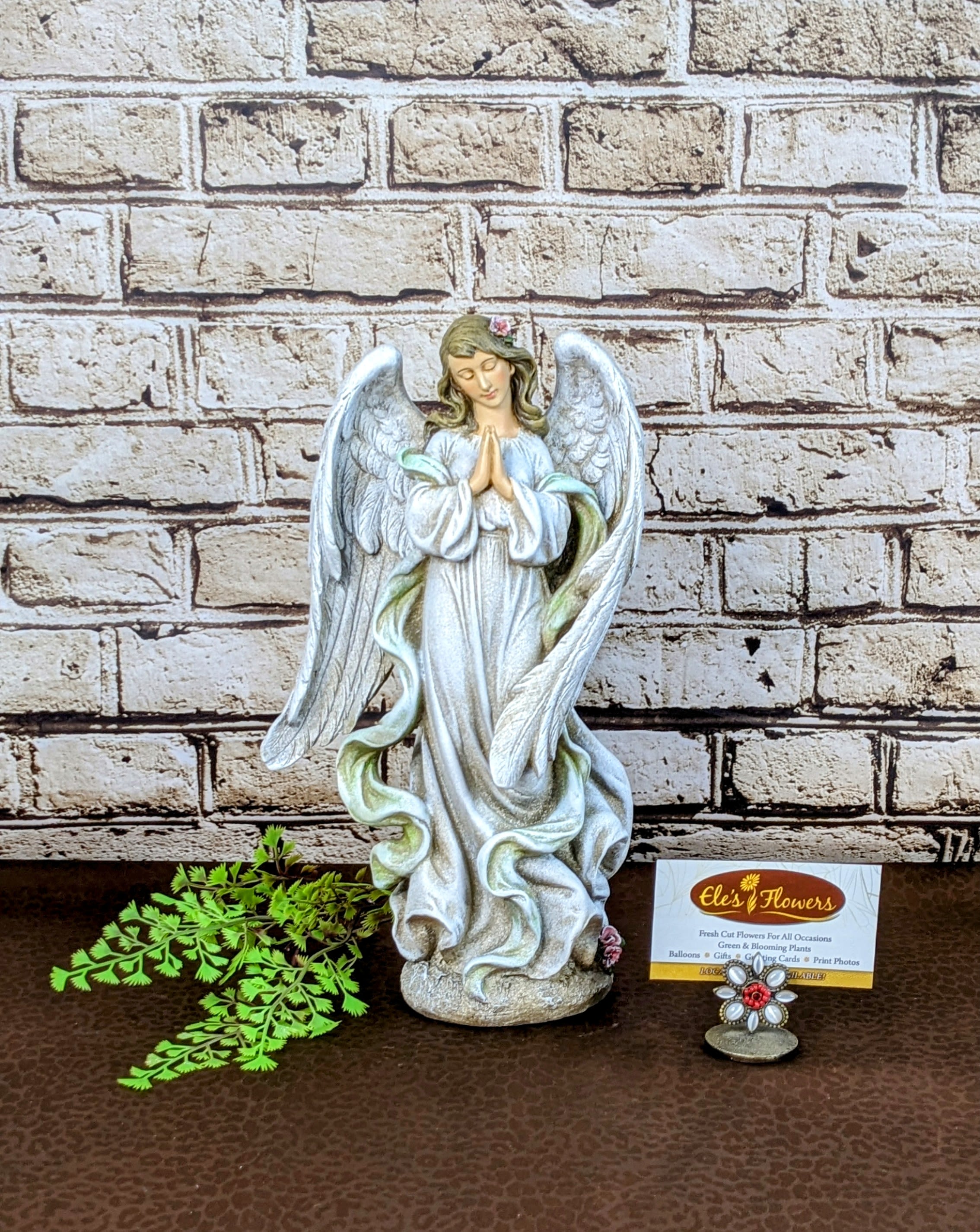 Heavenly Messenger Angel Heavenly Messenger Angel - This Heavenly Messenger Angel exudes peace and serenity, featuring a beautifully detailed design with flowing robes and intricately crafted wings. With hands clasped in prayer and a soft floral accent in her hair, this angel symbolizes hope and spiritual comfort. Made from durable resin with a stone-like finish, it’s perfect for indoor decor, memorial gifts, or as a heartfelt expression of sympathy. A timeless piece that brings grace and tranquility to any setting. Made from a resin material suitable for indoor use only. Approximate Dimensions: 13"H x 6"W