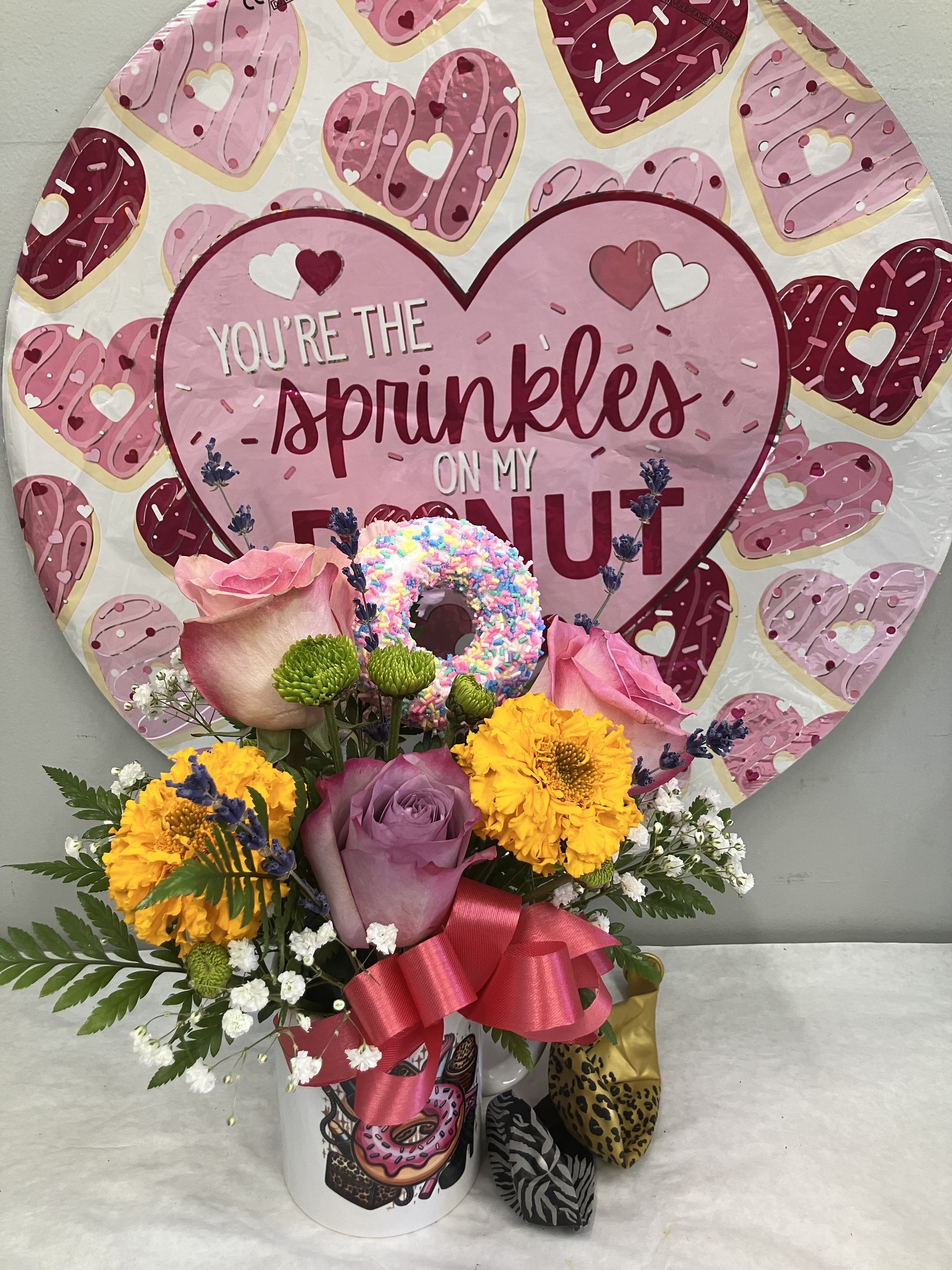 Donut Mug and Balloons - Cute donut mug with pink roses, pink gerbera daisy and baby’s breath. Comes with a Mylar balloon and two latex balloons