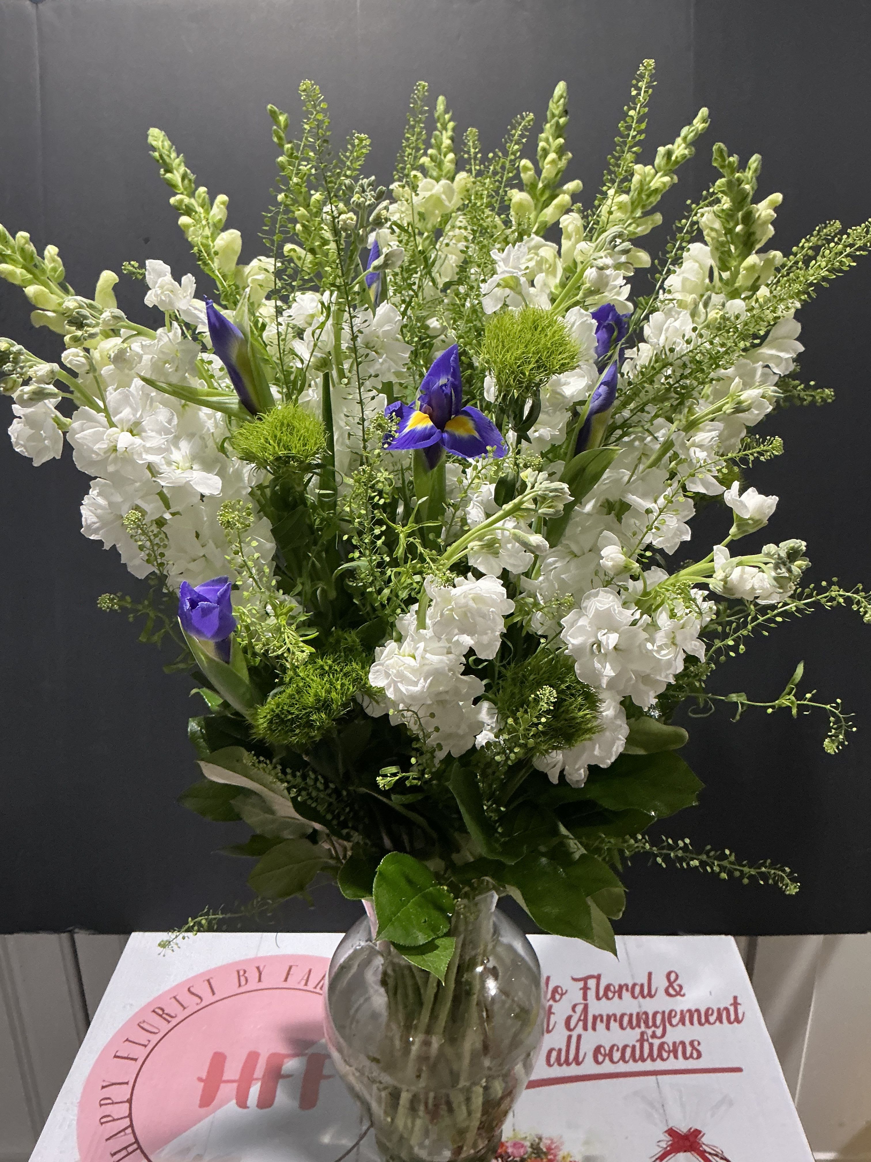 Blue symphony - This floral arrangement have a purposes to  express sympathy support together as a family allows you to cherish the memories of your family always have  you in our hearts.   1 cristal vase 6 stock,5 iris (white or blue) 4 snapdragon, dianthus lepidium 30H 20D