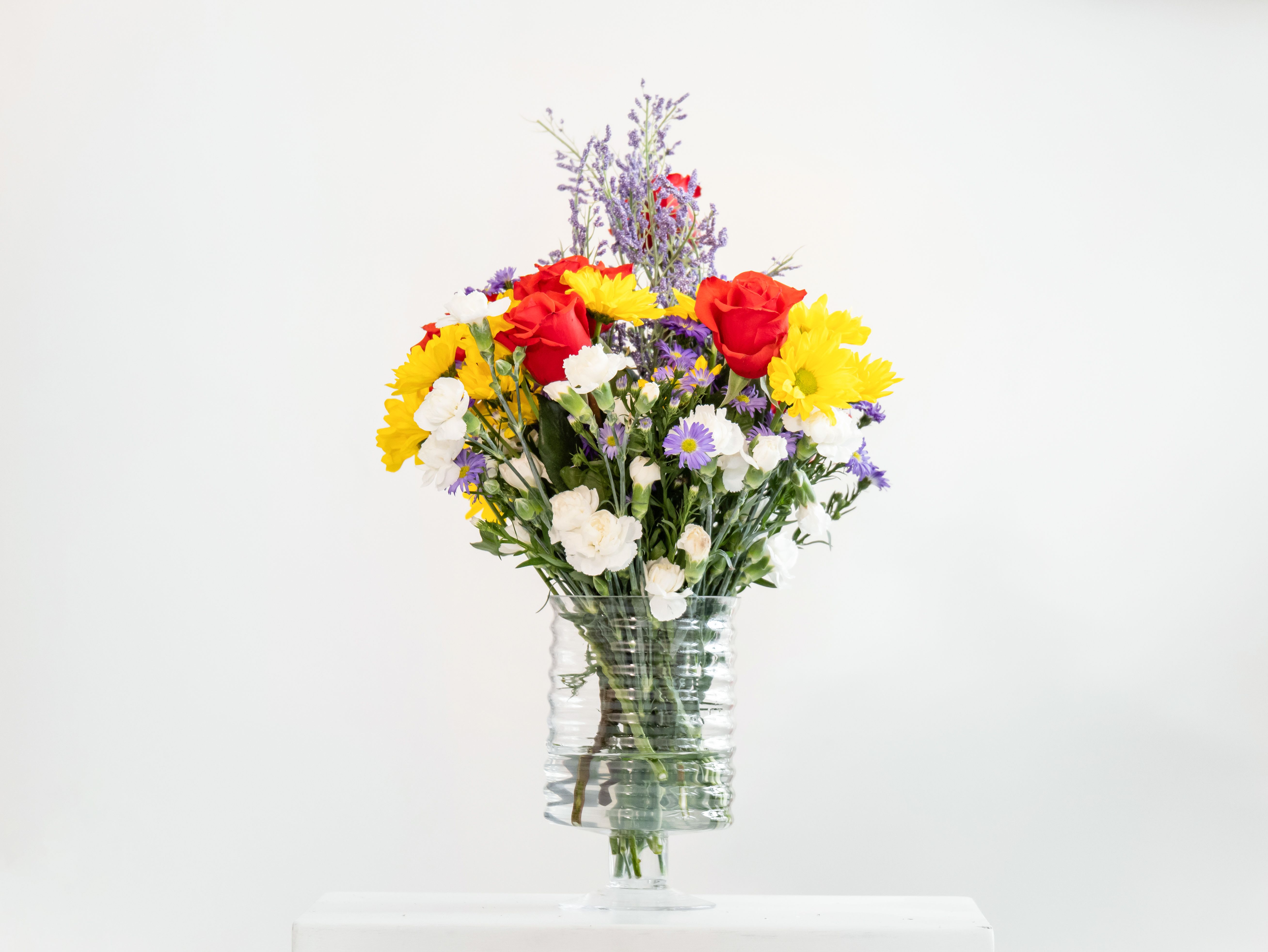 Springtime by Dixie's Flowers Springtime by Dixie's Flowers - This charming arrangement bursts with seasonal color and fragrance, featuring a cheerful blend of red roses, yellow daisies, lavender stock, white carnations. Accented with delicate baby’s breath and fresh greenery, it’s a joyful celebration of spring’s natural beauty—perfect for birthdays, thank-you, or simply brightening someone’s day.