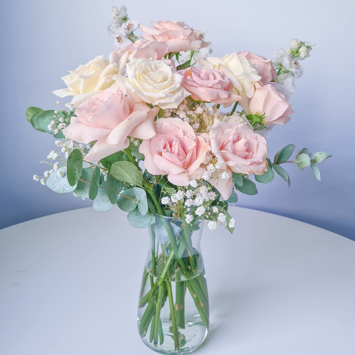 Pretty in Pink - A charming bouquet of soft pastel romance—blush-pink and creamy ivory roses nestled among feathery baby’s breath and dainty greenery. The plush, velvety petals bring a sense of gentle affection and grace, while the airy filler adds depth and light. This arrangement whispers sincerity and thoughtful admiration with every bloom—a perfect gift for anniversaries, new beginnings, or simply to say “I’m thinking of you.”