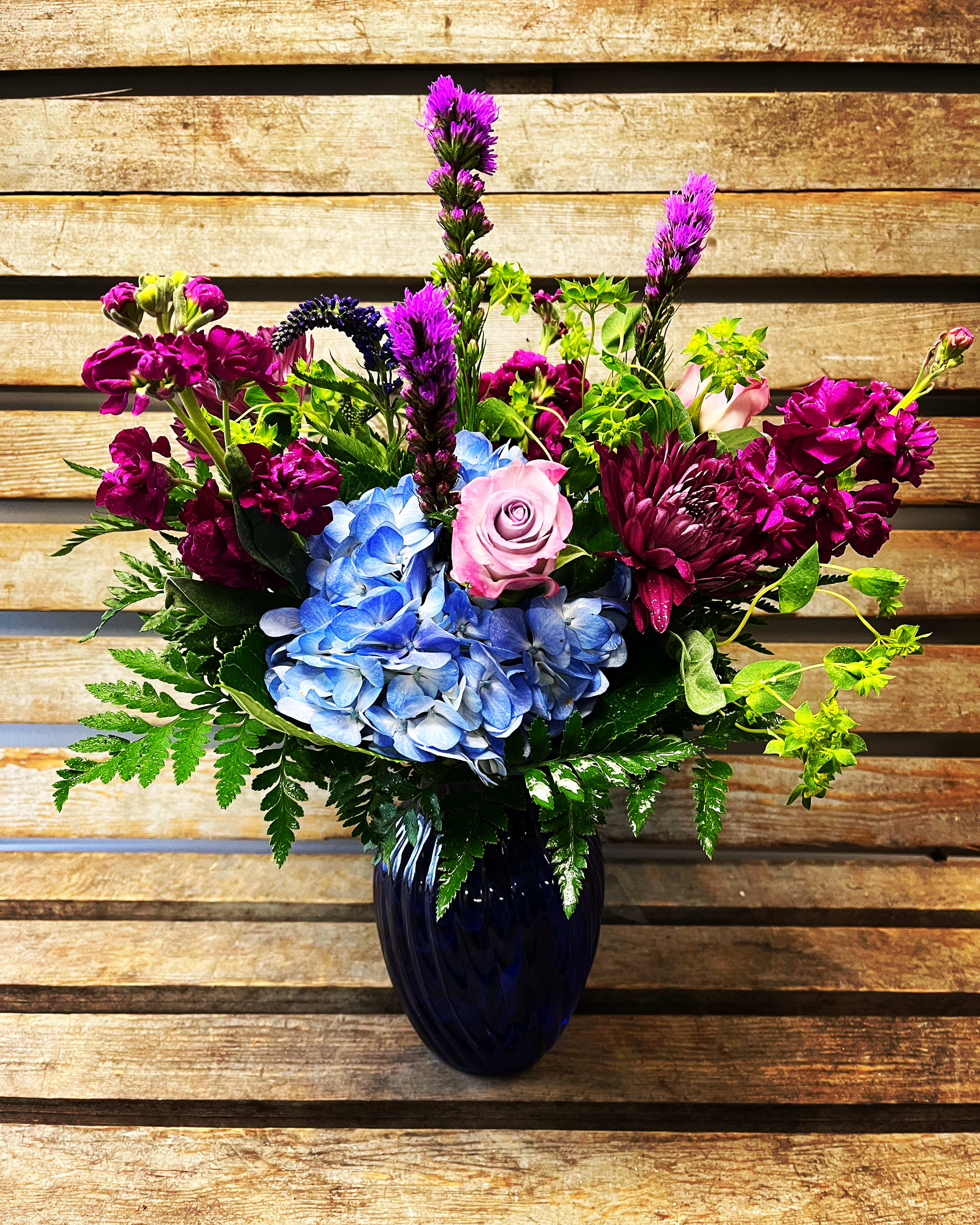 Blissful blue - Blissful blue. A cobalt blue vase filled with brilliant blue, fuchsia and purple seasonal flowers. If blue vase not available we will sub with a clear one 