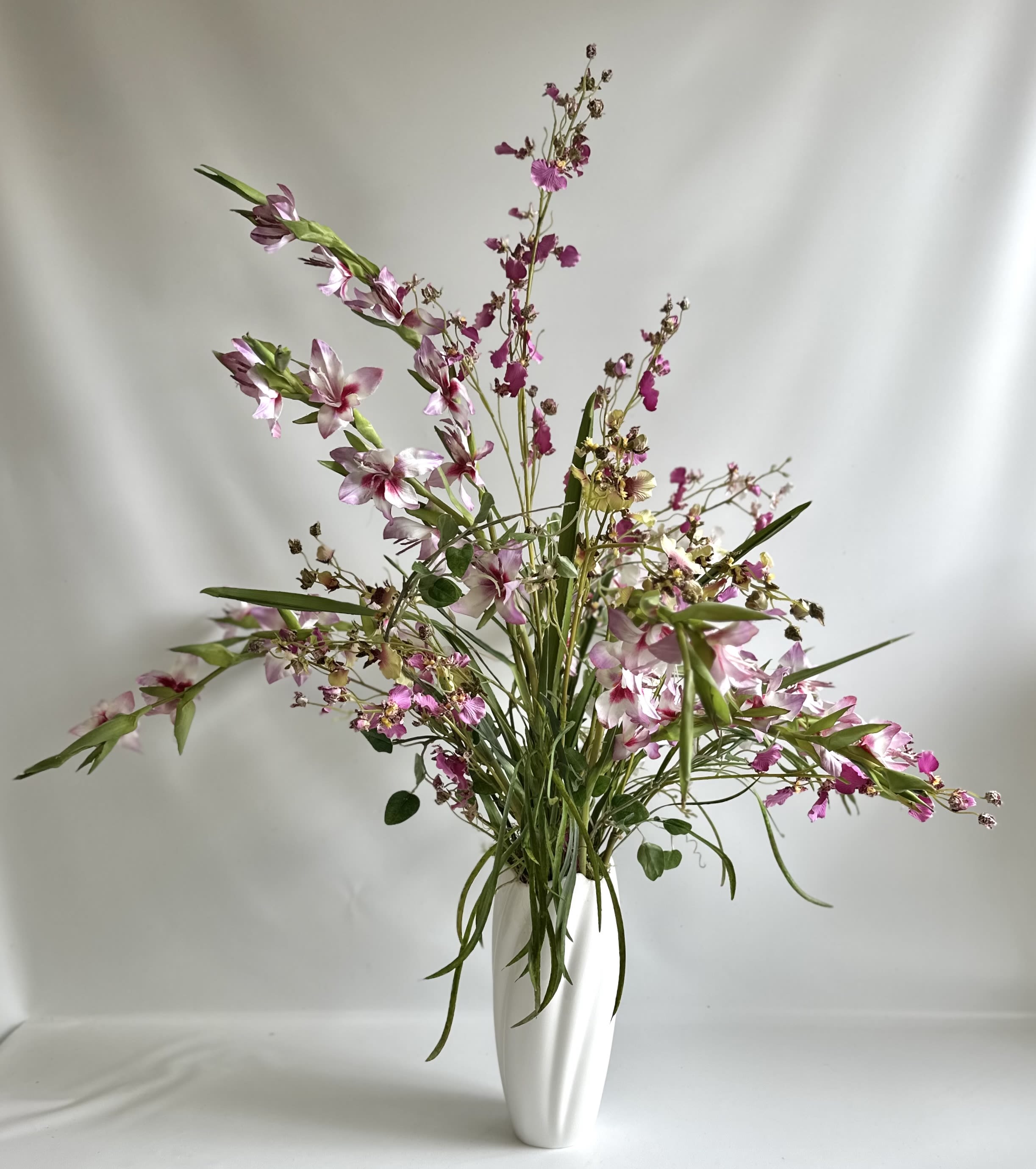 Mini Gladiola and Orchid Faux/ Silk Floral Arrangement - A white vase filled with faux mini Gladiolas and Orchids. 34” tall