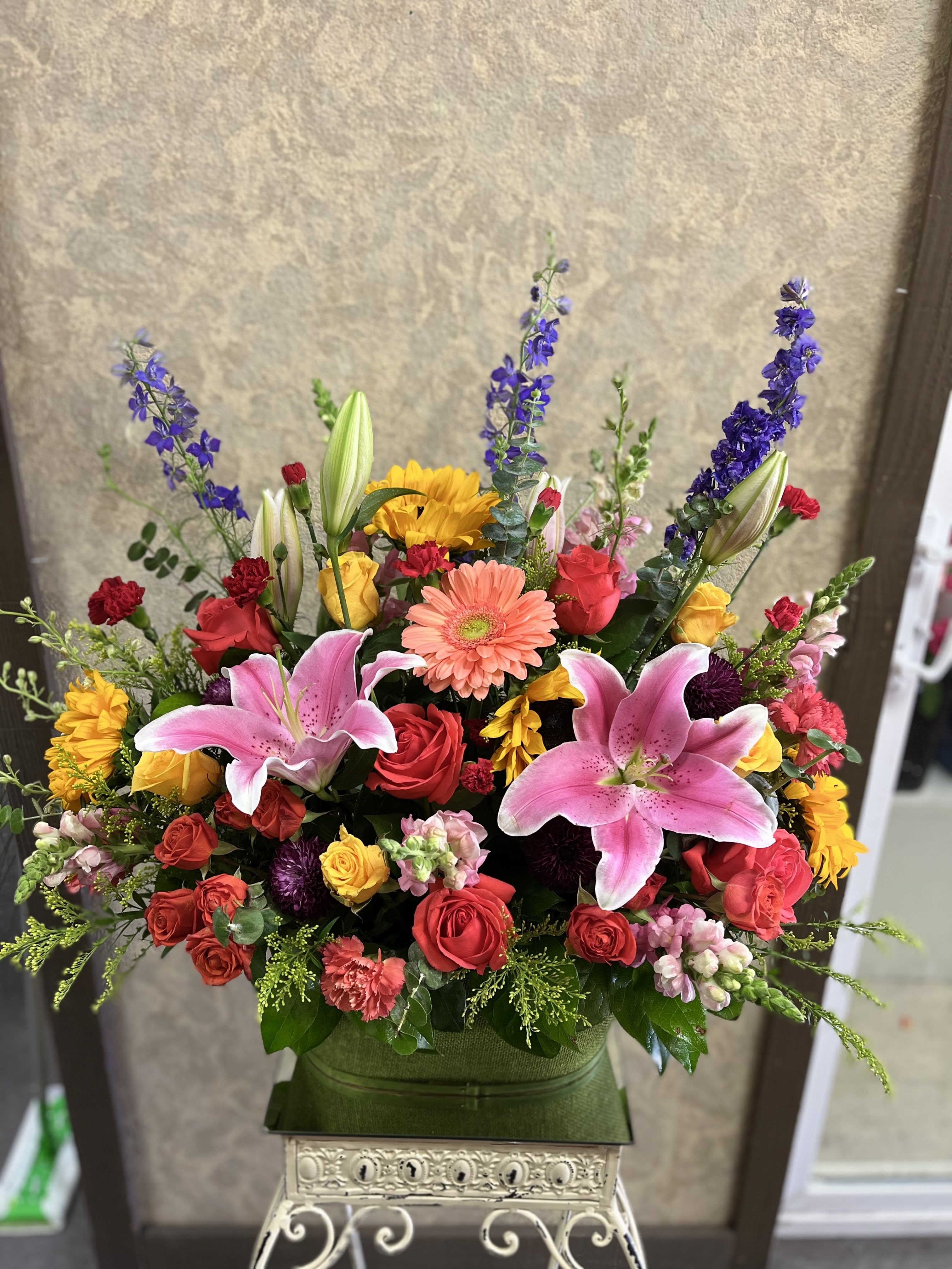 Brighter Days Ahead - In times of sorrow and loss, this design is will them know there are brighter days ahead during this difficult times.  This basket is full of fresh and colorful blooms. Recipe: Orange Roses, Yellow Roses, Orange Spray Roses, Sunflowers, fresh, bright yellow roses and Pink Lilies, Gerbera daisies, Pink Snapdragons, Purple Larkspur, Orange and Red Carnations and more in a green basket. Seasonal: All year round Design View: Front Facing View Photo shown: Standard
