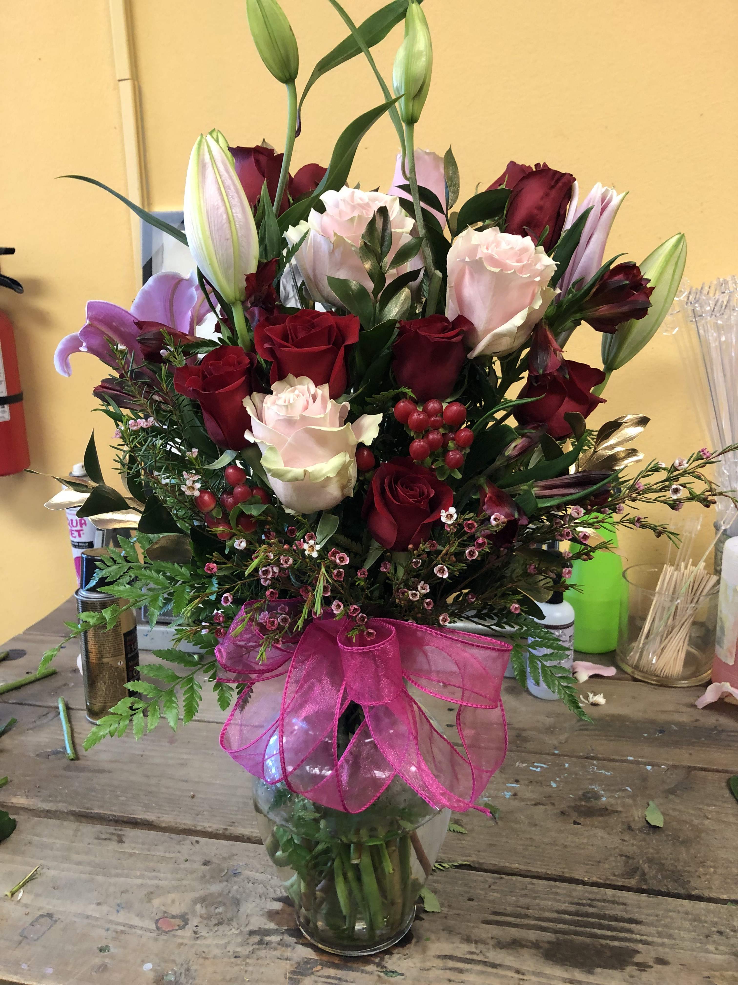 SIMPLE LOVE SIMPLE LOVE - Vase arrangement to include 6 pink roses and 6 red roses, lilies, gold leaves and wax filler deluxe to include 15 roses total and 2 lilies Premium to include 18 roses and 3 lilies