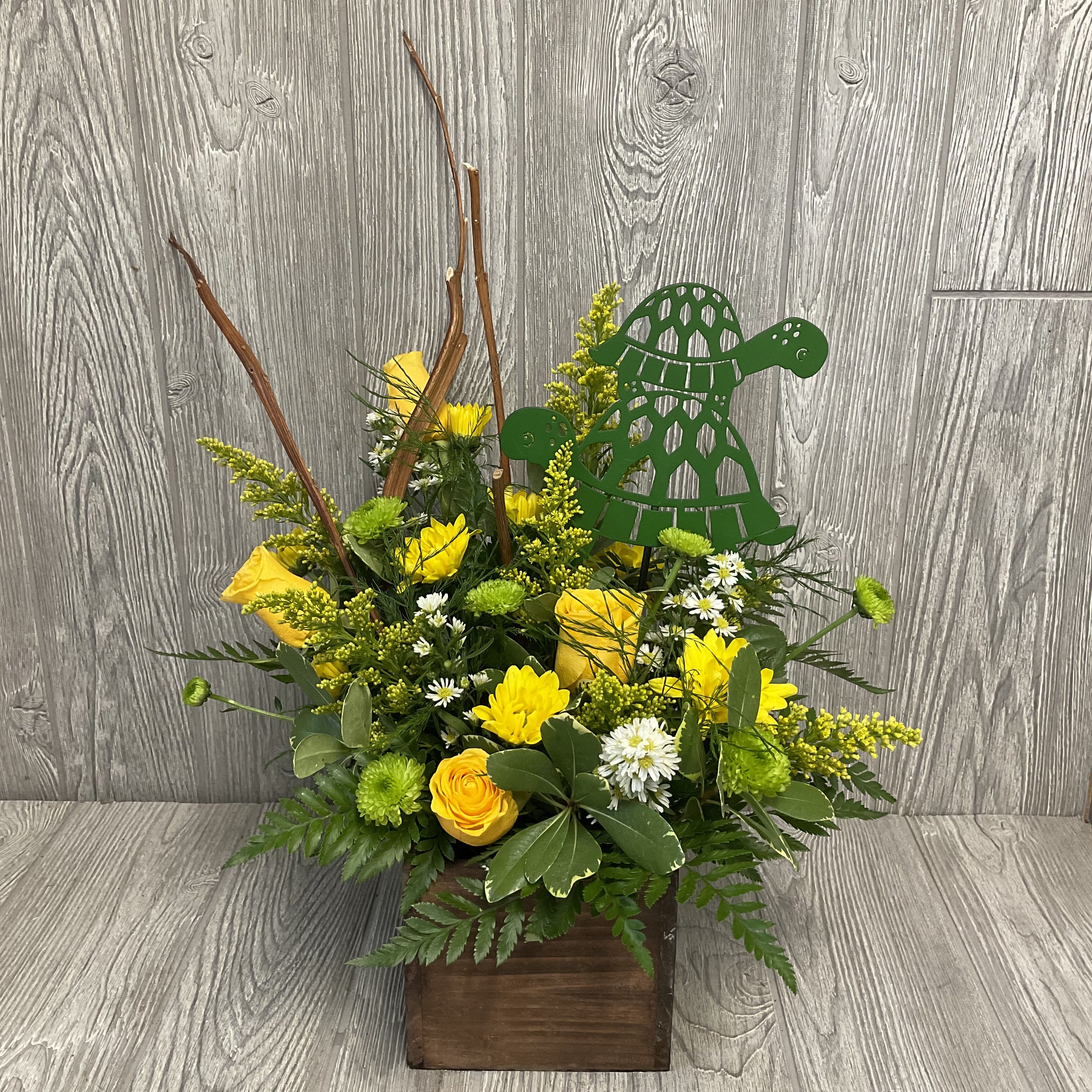Turtley Tubular - Cute turtle arrangement in a wooden box with a metal turtle pick prefect for the turtle lover in your life. Flowers and colors may vary.