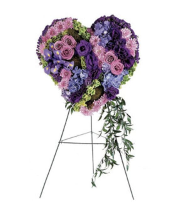 Violet Heart Violet Heart - This heart-shaped wreath in graceful shades of purple ia a timeless symbol of love and remembrance. The soft, rich hues of cherished memories, deep bonds, and a heartfelt goodbye. It's a beautiful tribute for honoring a soul who brought depth, grace, and beauty into the lives of others.