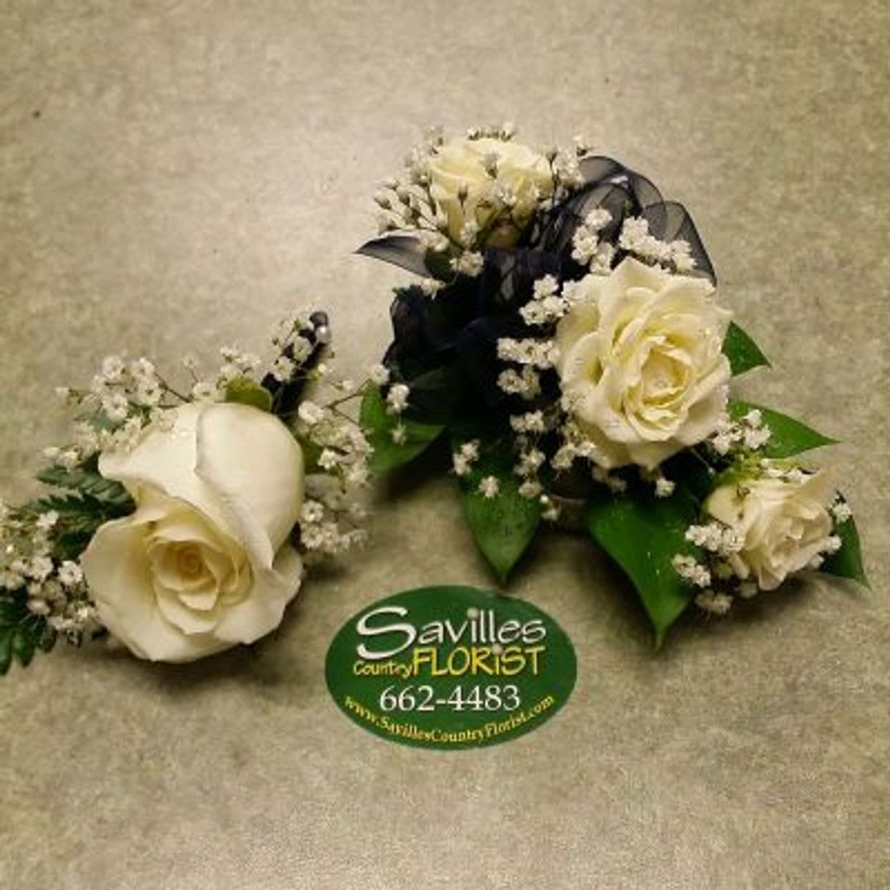 Corsage Bout White spray Rose Combo Corsage Bout White spray Rose Combo - Wrist Corsage and Boutonniere Combo. Wrist corsage features 3 white spray roses with sheer black bow and babies breath and the boutonniere has 1 white rose, babies breath and a black sheer ribbon stem wrap.