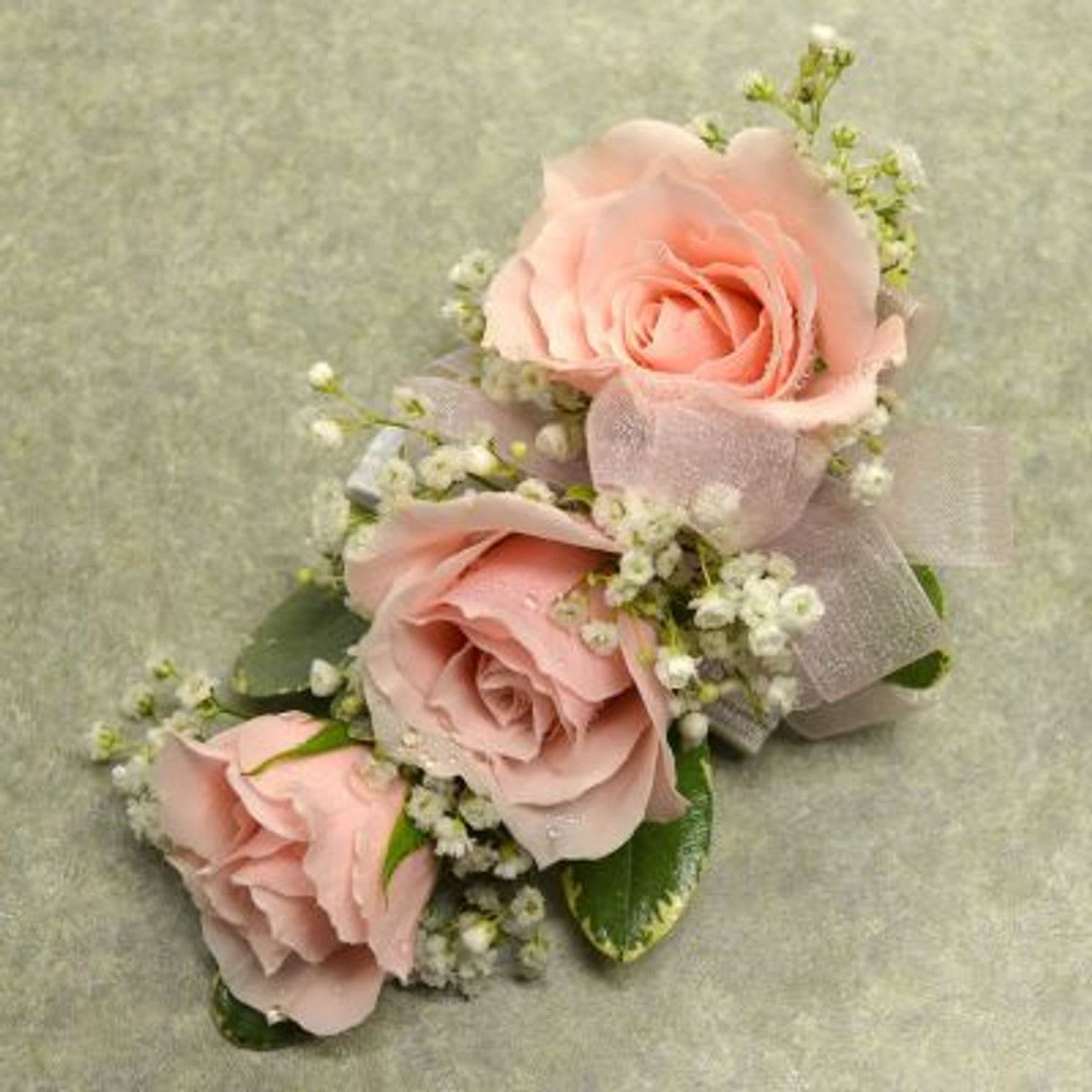 Corsage with 3 Lt Pink spray Roses Corsage with 3 Lt Pink spray Roses - Wrist corsage with three light pink spray roses, babies breath and pink sheer ribbon.