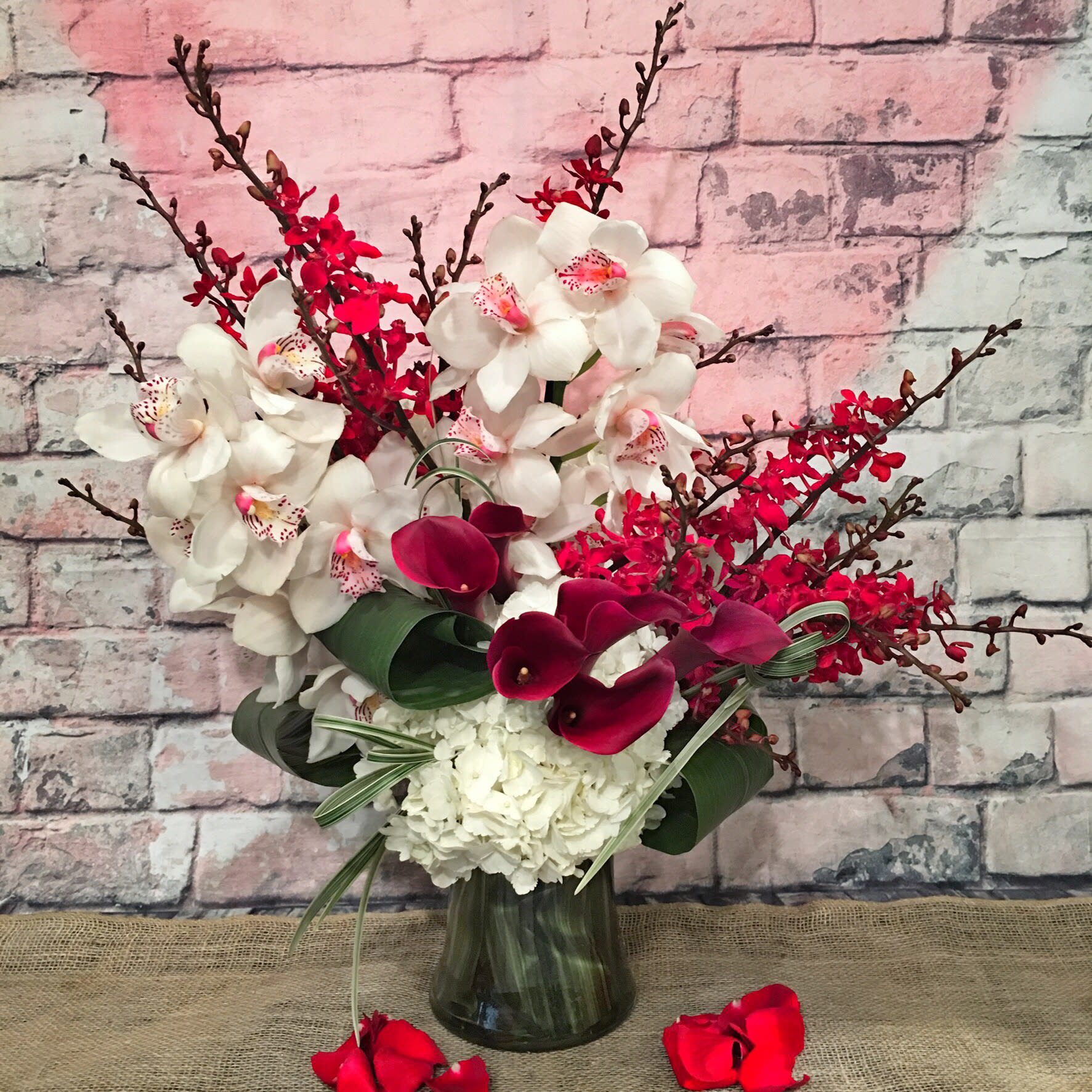 CHARMFULLY YOURS - WHITE CYMBIDIUM, JAMES STORY ORCHIDS, WHITE HYDRANGEAS AND RED CALLA LILY.