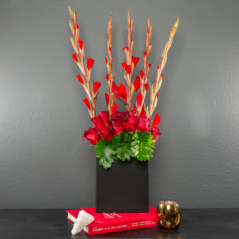 SO glad you're in my life - This stunning, long lasting arrangement is made of gorgeous gladiolus, and roses win a modern black vase. Colors can be adjusted from reds if desired.   All of Zalea's arrangements are designed with the freshest ingredients. If we happen to be out of a type of bloom, or a color (or if they're not the freshest), our team will reach out to let you know what the substitution options are! Substitutions can happen with all fresh product - so we make sure you have the freshest possible arrangements.