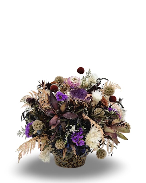 Dried Garden Dried Garden - Preserved Beauty is a medium sized dried arrangement with a playful one sided design. Featuring a soft mix of white, blush pink, and gentle yellow tones, it brings a light and airy feel to any space with the natural charm of everlasting blooms.