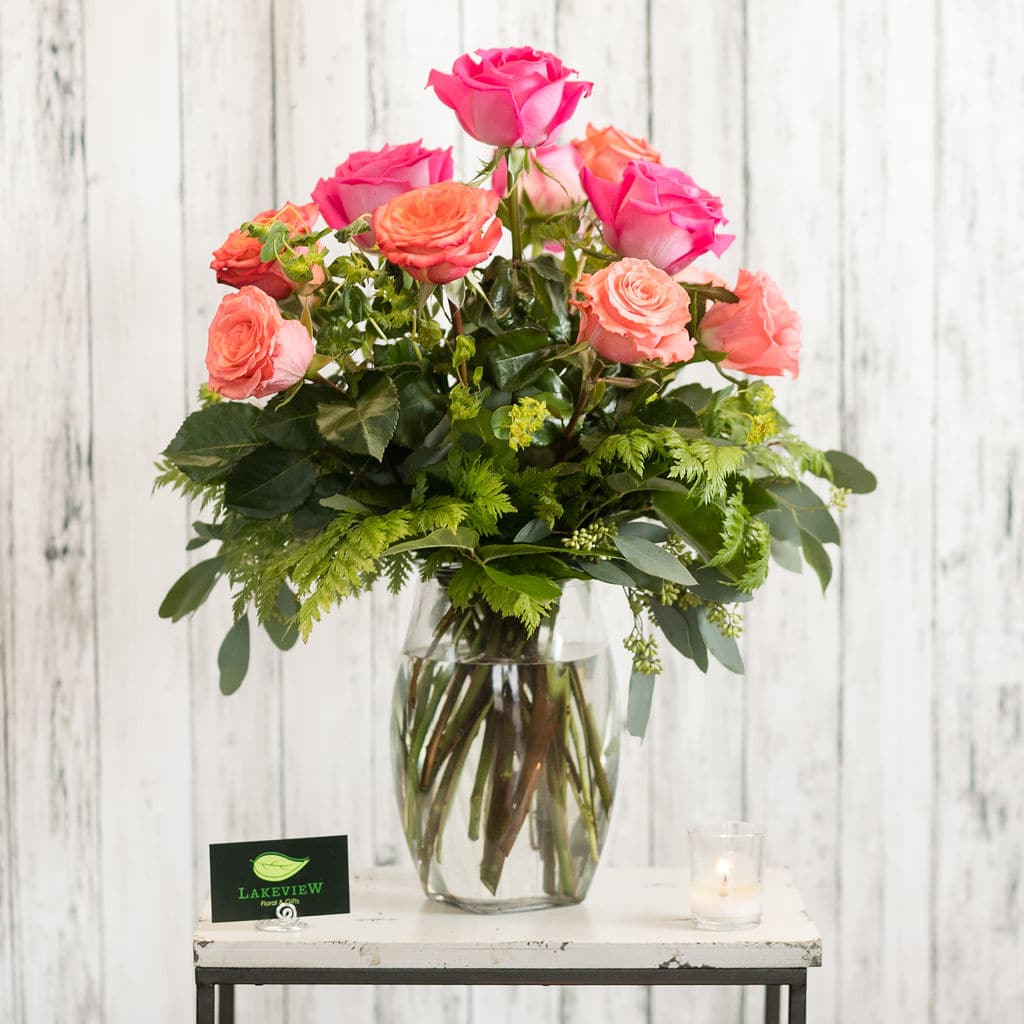 Rumba Rumba - Sweet as sugar~ 12 roses in shades of hot pink, coral and orange are arranged in a stylish glass vase. Approximate Dimensions: 15" W x 22" H