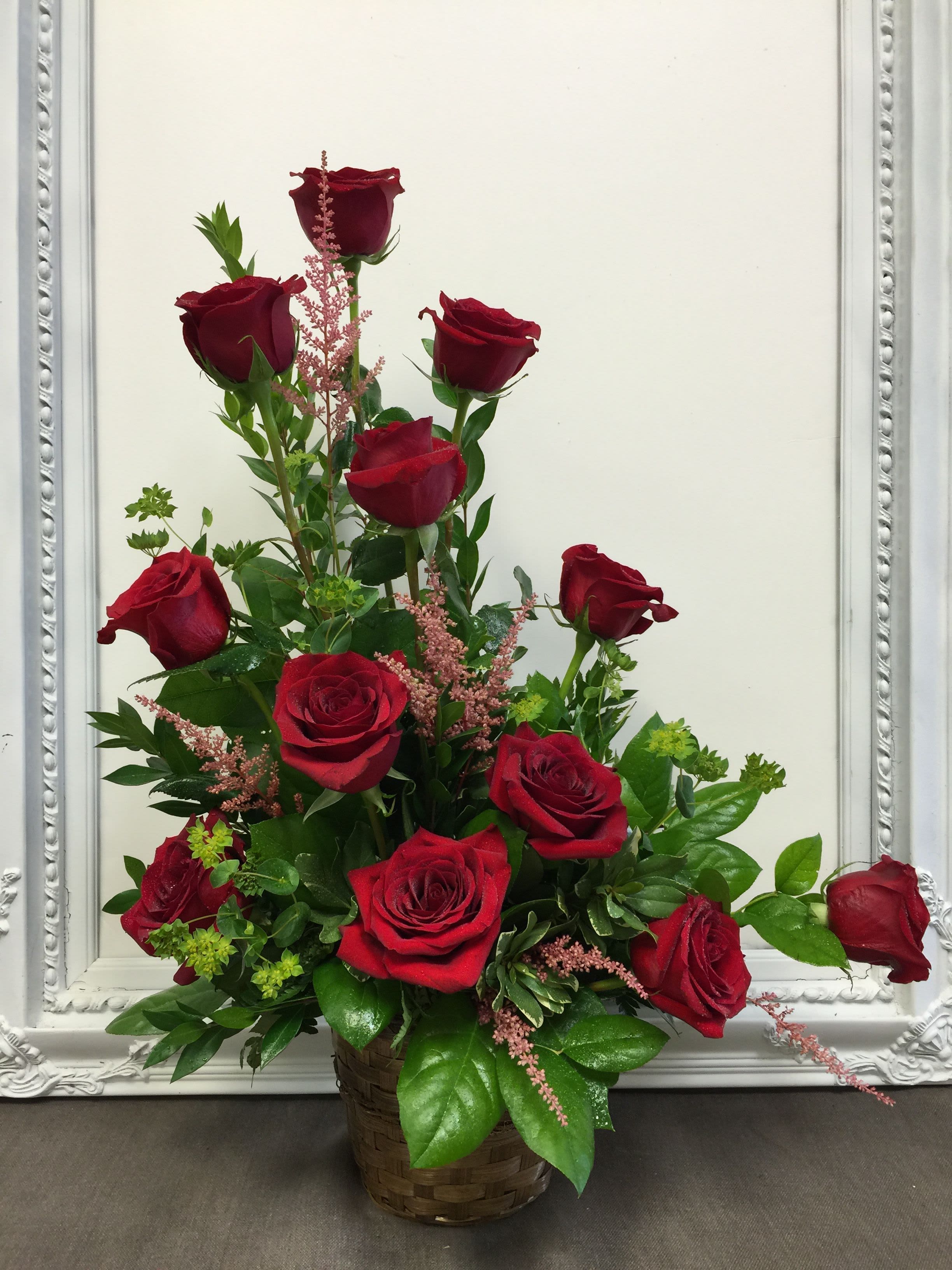 Classic Devotion Rose Basket - Express your deepest affection this Valentine’s Day with the Classic Devotion Rose Basket, a timeless arrangement designed to capture hearts. Overflowing with lush, velvety red roses—the universal symbol of love—this bouquet is artfully arranged with fresh greenery and delicate pink accents for a stunning, romantic display.  Presented in a charming woven basket, this arrangement exudes rustic elegance while maintaining a sophisticated flair, making it perfect for romantic gestures, anniversaries, or heartfelt surprises. Its natural beauty and vibrant colors are sure to leave a lasting impression.  Why It’s Perfect for Valentine’s Day:  Abundant Red Roses: Symbolize deep love, passion, and commitment.  Lush Greenery &amp; Pink Accents: Add texture and contrast for a dynamic, romantic look.  Charming Basket Presentation: A rustic yet elegant display that’s ready to gift.  Long-Lasting Design: Ideal as a centerpiece or heartfelt gift for your Valentine.
