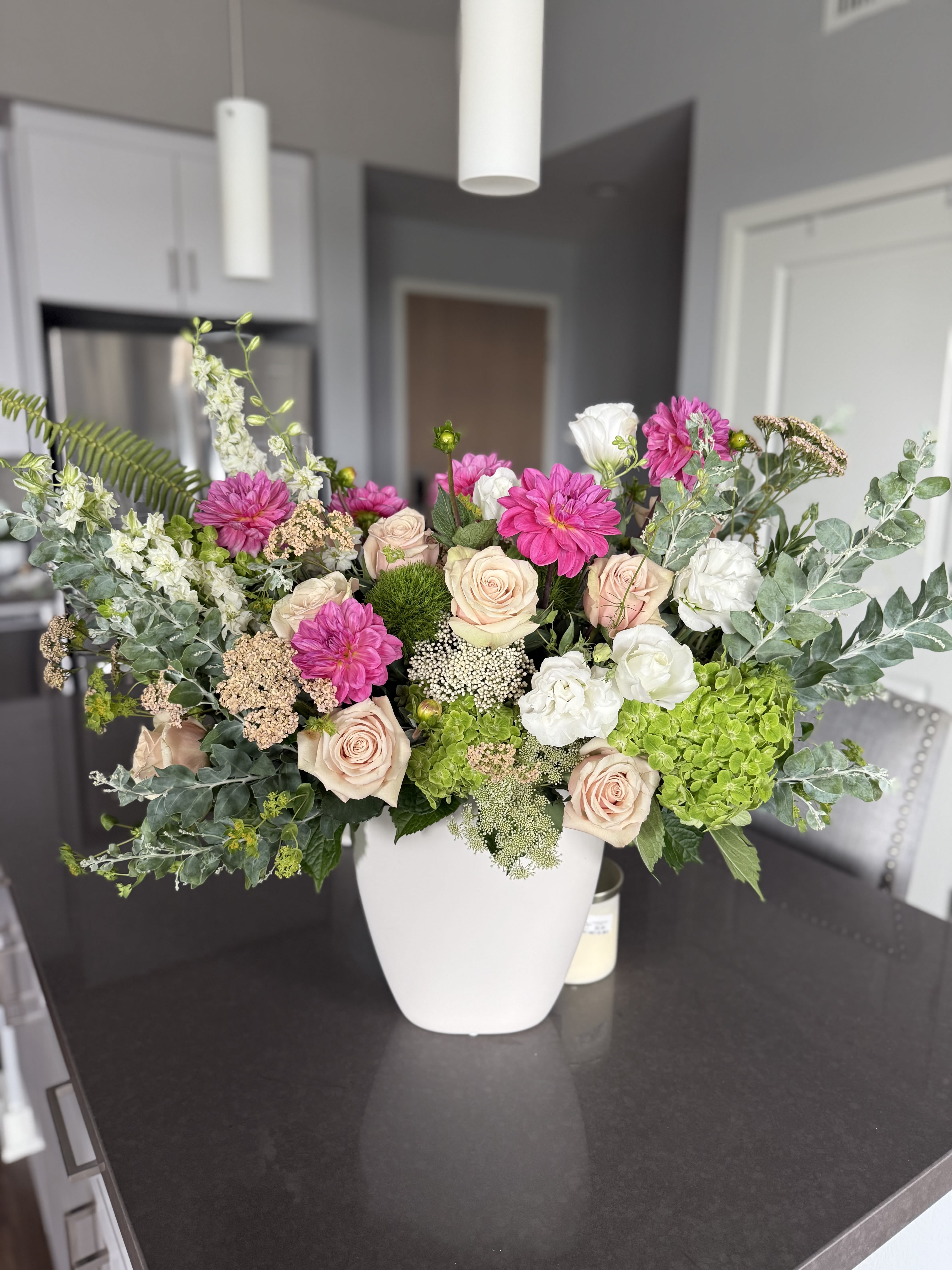 Blush garden luxe Blush garden luxe - Blushing Garden Luxe is an exquisite luxury floral arrangement overflowing with lush garden textures and vibrant colors. Featuring elegant blush roses, crisp white lisianthus, vivid fuchsia dahlias, soft green hydrangeas, delicate Queen Anne’s lace, and fresh greenery, this arrangement brings sophisticated beauty to any space. Perfect for modern homes, upscale offices, events, or as a statement gift for birthdays, anniversaries, or celebrations, its elegant white ceramic vessel complements contemporary décor. • Large, premium designer arrangement • Long-lasting blooms selected for freshness • Ideal for kitchen islands, foyers, corporate lobbies, or dining tables • Available for same-day delivery in Los Angeles (customize for your area)
