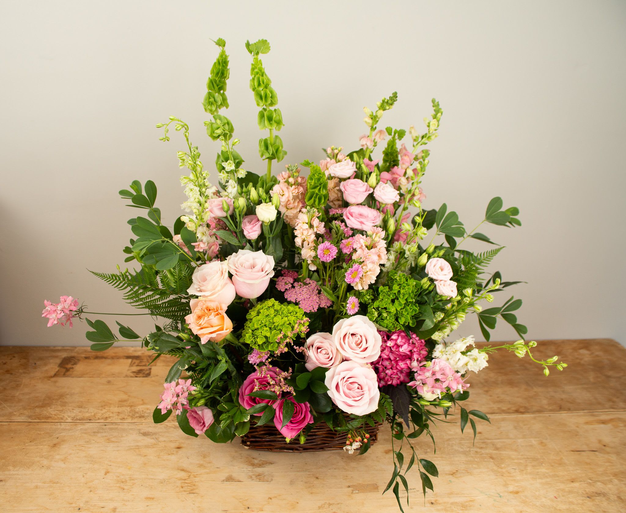 Pastel Sympathy Traditions  - Our classically designed funeral basket in soft, pastel tones. Flower selections may include stems in shades of pinks, lavenders, peach, etc.  This showy display of flowers is best suited for sending to the funeral home.  Approx. 30&quot;x24&quot; wide. 