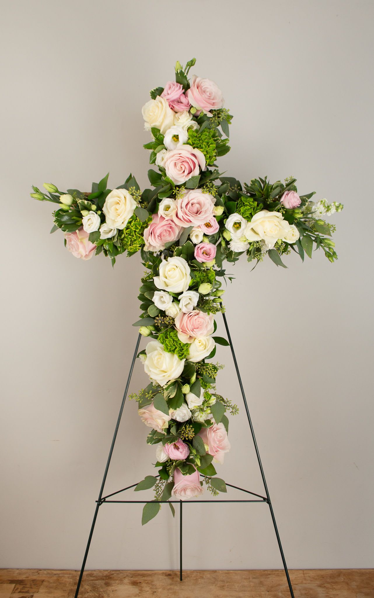 Blessings Funeral Cross - A graceful expression of faith, love, and remembrance. The Blessings floral cross is a beautiful tribute, symbolizing peace and eternal rest. Thoughtfully arranged with seasonal blooms, it can be customized in a variety of color palettes to reflect your loved one’s spirit or favorite hues.