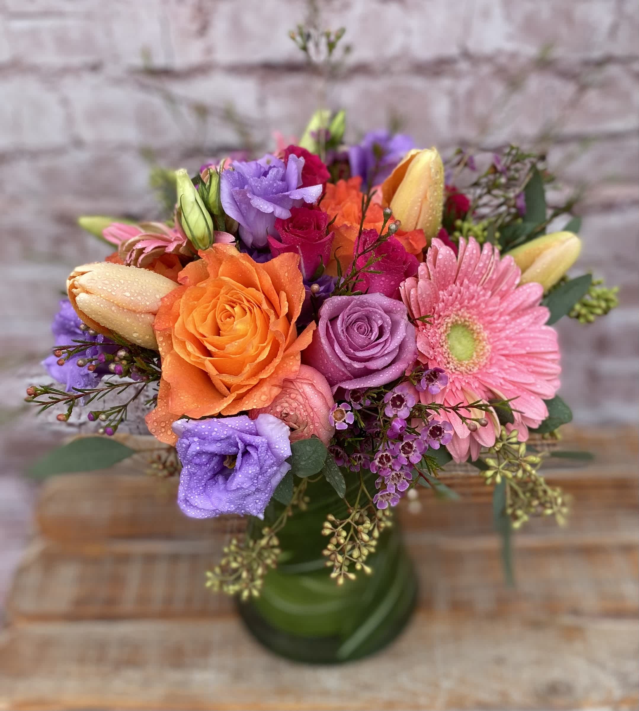 Sophia's Summer Breeze - An assortment of Roses, Gerbera Daisies, Tulips, and Lilies in a vase. Tulips will be added when in season. We will use a suitable replacement when out of season.