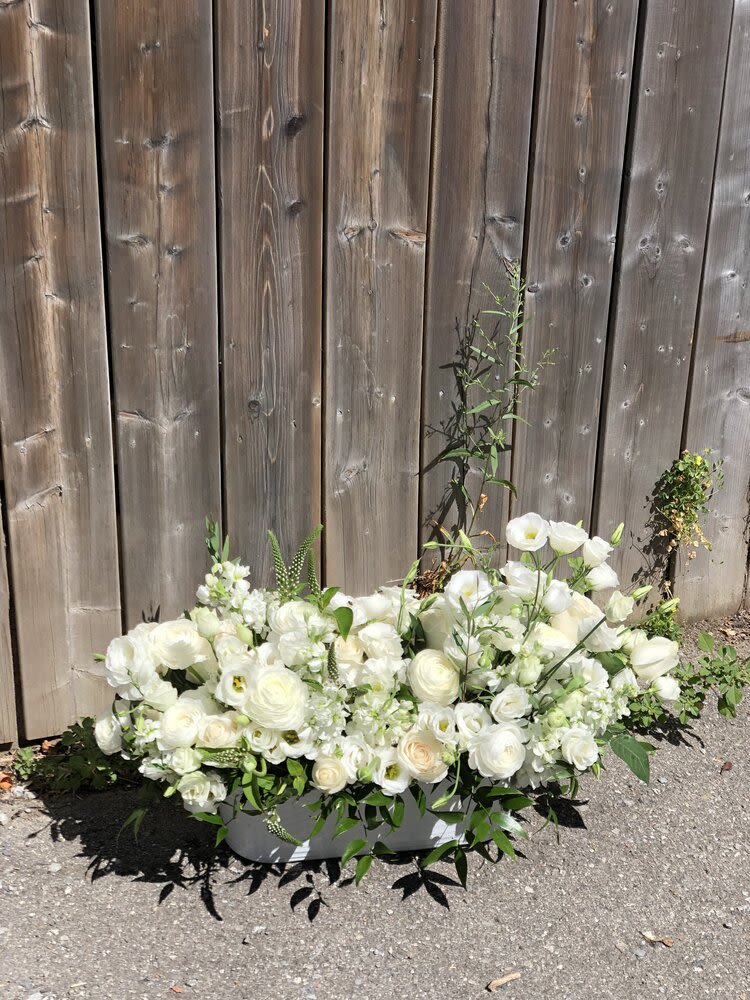 Summer 9 - Flower arrangement in a container with white lisianthus, ranunculus, cream roses, veronica, stock and some greeneries. *Picture shows deluxe size  *Depending on availability, flowers may change