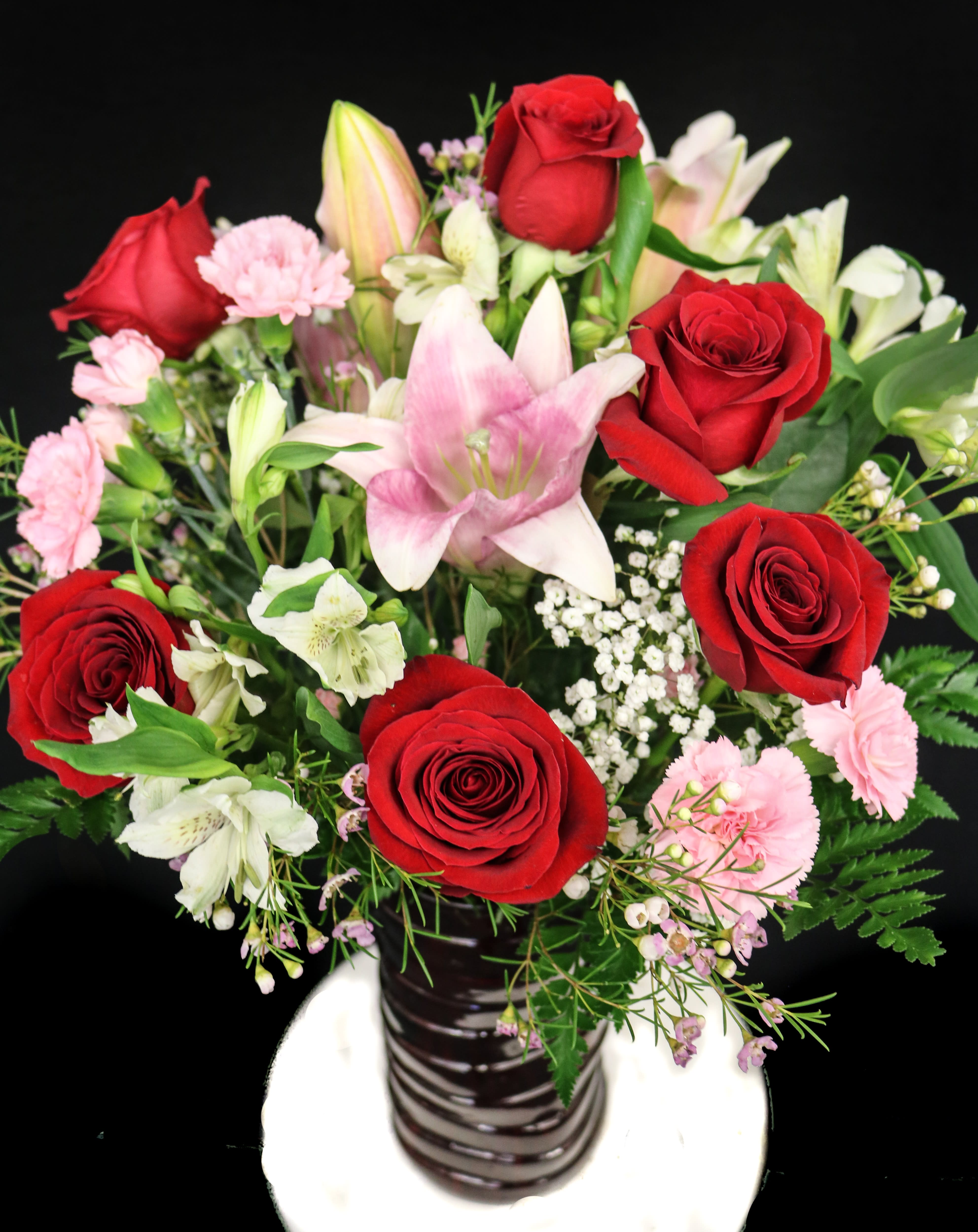 Lily & Rose Sensation Lily & Rose Sensation - pink lilies and six red roses arranged with pink mini carnations and white alstroemeria in an elegant red vase